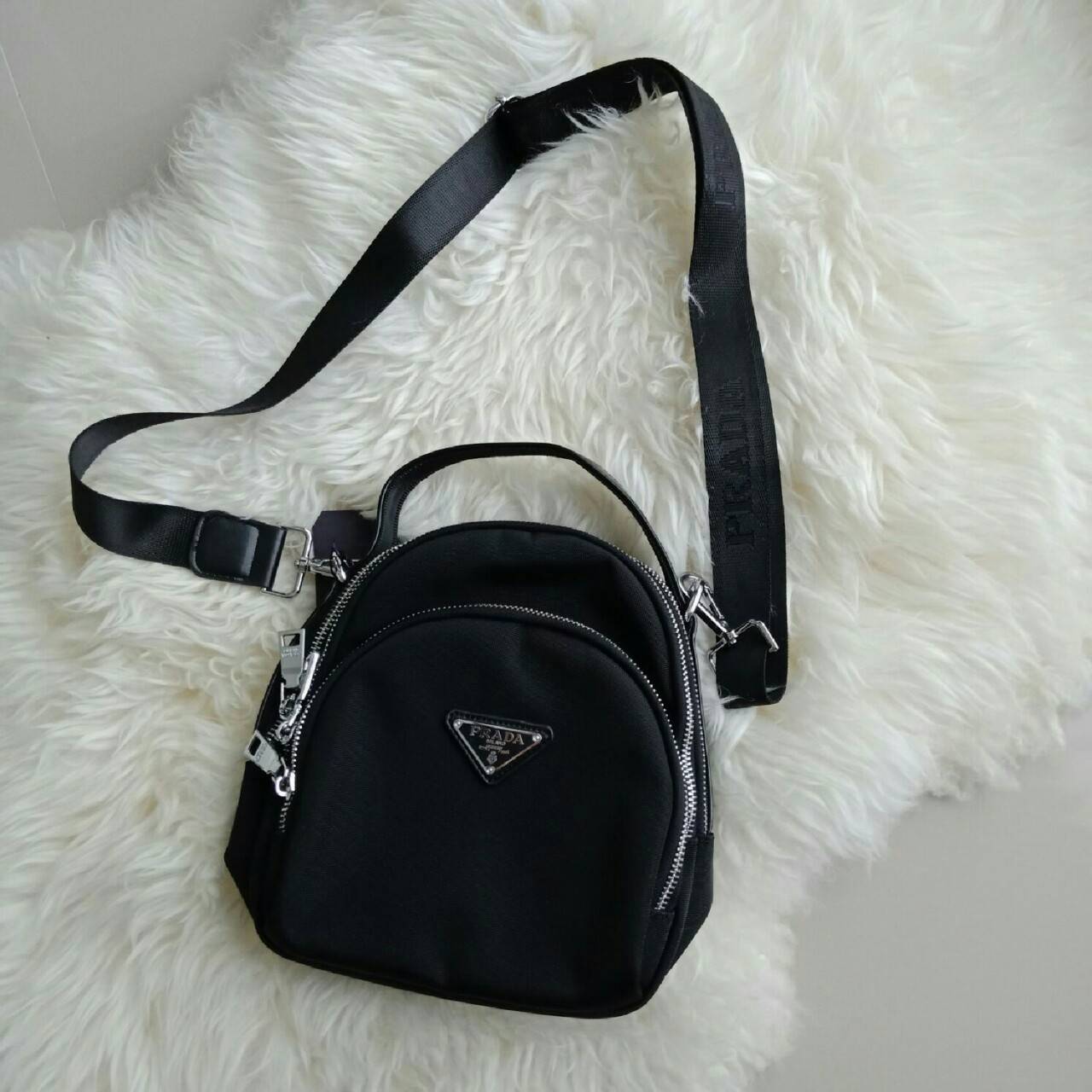 NEW ARRIVAL จากแบรนด์ Prada ใบเดียวใช้ได้3ทรง คุ้มมากๆคะ จะถือ สะพายข้าง หรือทำเป็นเป้สะพายหลัง ก็ได้คะ ขนาดกะทัดรัด วัสดุทำจากผ้า Polyester อย่างดีสามารถกันน้ำได้คะ มีช่องแยกให้ 3ช่องคะ ใส่กระเป๋าตังค์ มือถือ ได้สบายคะ อะไหล่เงินทั้งใบ มาพร้อมสายสะพายยาว