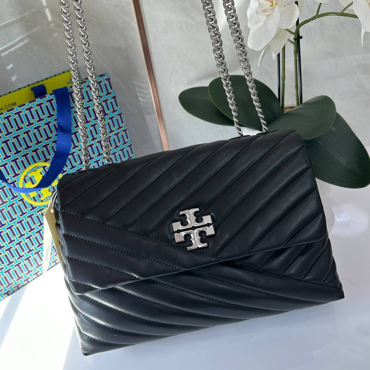 TORY BURCH KIRA CHEVRON CONVERTIBLE SHOULDER BAG กระเป๋าสะพายไซส์ใหญ่ หรูหราสุดคลาสสิก วัสดุหนังแกะทั้งใบ เปิด-ปิดด้วยกระดุมแม่เหล็ก ภายในเป็นช่องโล่ง ใส่ของสำคัญได้ครบ สายสะพายในตัวปรับได้ 2 แบบ สะพายไหล่โซ่คู่หรือจะ ครอสบอดี้ก็เริ่ดคะ