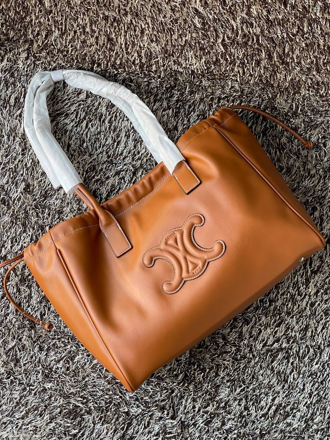 Celine cabas drawstring cuir triomphe in Smooth Calfskin / celine shopping bag เป็นกระเป๋าที่ดีไซน์คลาสสิก เรียบหรู ไม่ตกยุค โดดเด่นเพราะมีโลโก้อยู่ตรงกลาง ออกแบบมาให้ใส่ของใช้ในชีวิตประจำวัน ซึ่งคุณสามารถใช้เป็นกระเป๋าถือหรือสะพายไหล่ก็ล้วนเก๋และมีความคล