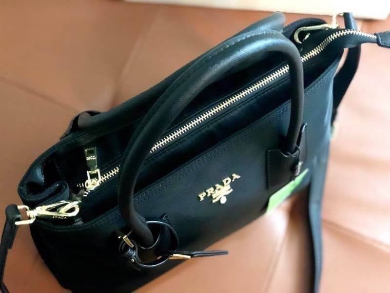 PRADA NYLON BAG Limited edition พรีเมี่ยมกิ้ฟจากเคาน์เตอร์แบรนด์ต่างประเทศ วัสดุ Nylon เนื้อหนาคุณภาพดีตามแบบฉบับแบรนด์ ด้านหน้าประดับทองโลโก้หรู ด้านข้างมีกระดุมปรับขยายได้ หูจับหนังแข็งแรง พร้อมสายสะพายยาวปรับระดับได้ มีหมุดรองฐานกันรอยสี่มุม ภายใน Poly