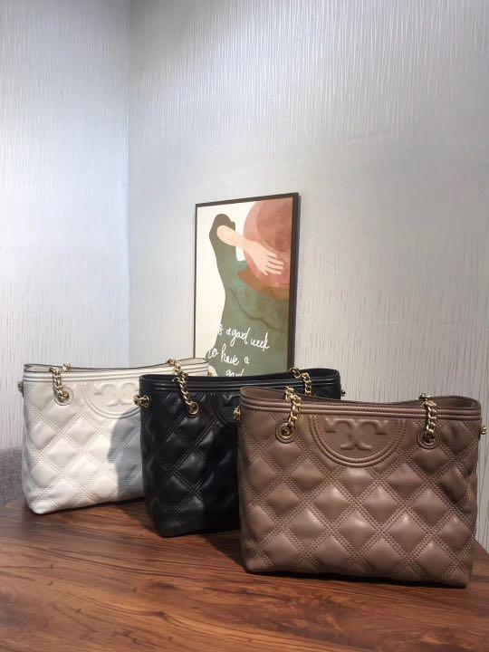 Tory Burch Fleming Soft Small Tote Bag เป็นกระเป๋าสะพายไหล่น่ารัก ๆ สักใบที่มีดีไซน์โดดเด่น สะดุดตา ใน Collection เรียกได้ว่าขายดีอันดับต้น ๆ ของแบรนด์ ใช้ได้ในลุคช์ทางการและกึ่งทางการ ดีเทลการตัดเย็บพิมพ์ลายนูนคู่กับแพทเทิร์นสี่เหลี่ยมทรงเพชร ที่ช่วยเพิ่