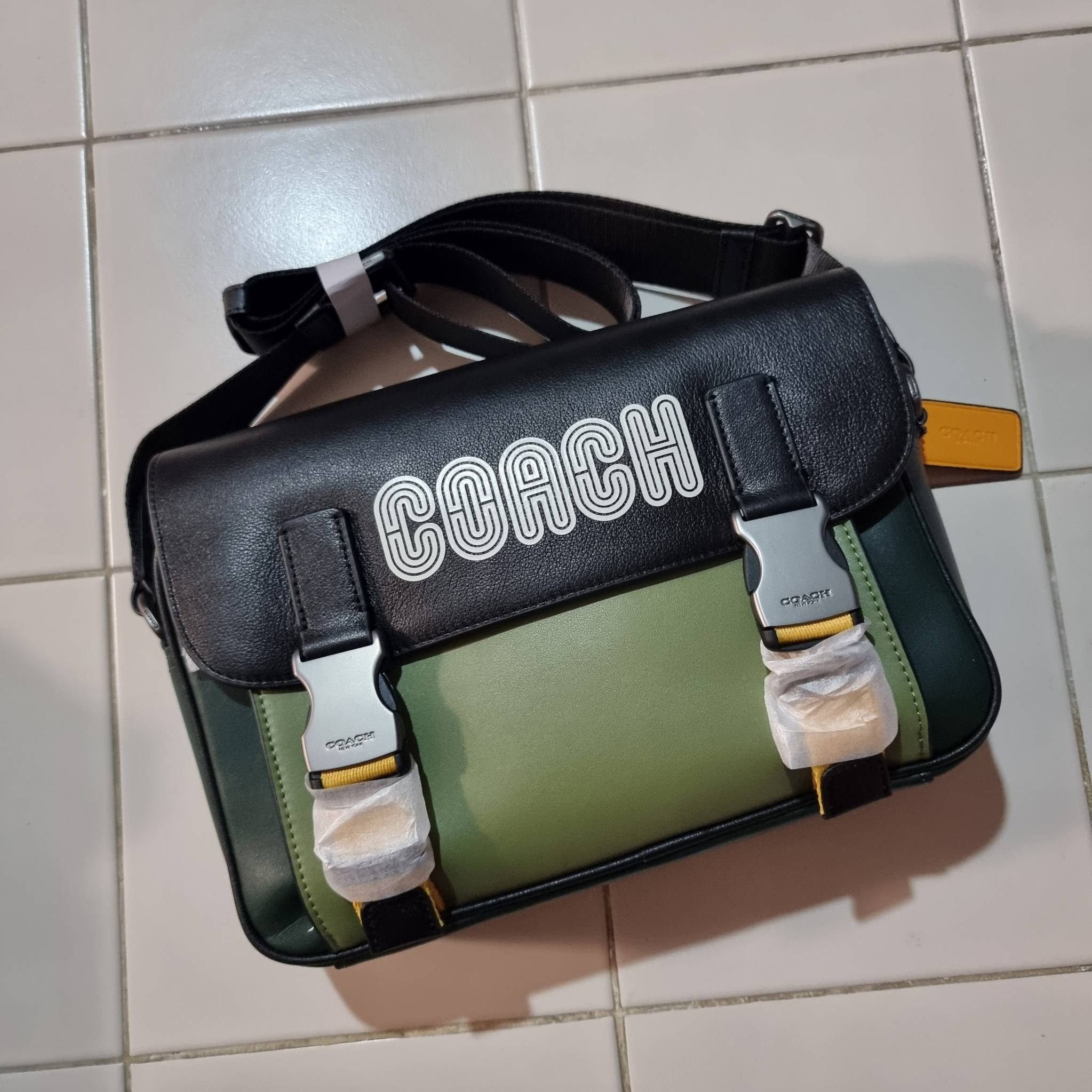 COACH TRACK CROSSBODY IN COLORBLOCK WITH COACH PATCH C6657 C8128 หล่อบอกต่ออีกหนึ่ง กระเป๋าสะพายทรงแมสเซ็นเจอร์ รุ่นเอาใจหนุ่มๆ ที่สาวๆก็อยากใช้!! ด้วยดีไซน์สีคัลเลอร์บล็อคที่โดดเด่น ทำให้ดูน่าใช้งาน วัสดุหนังแท้ สวยคมซ่อนหรู ฝากระเป๋ามีตัวล็อคแน่นหนา เปิ