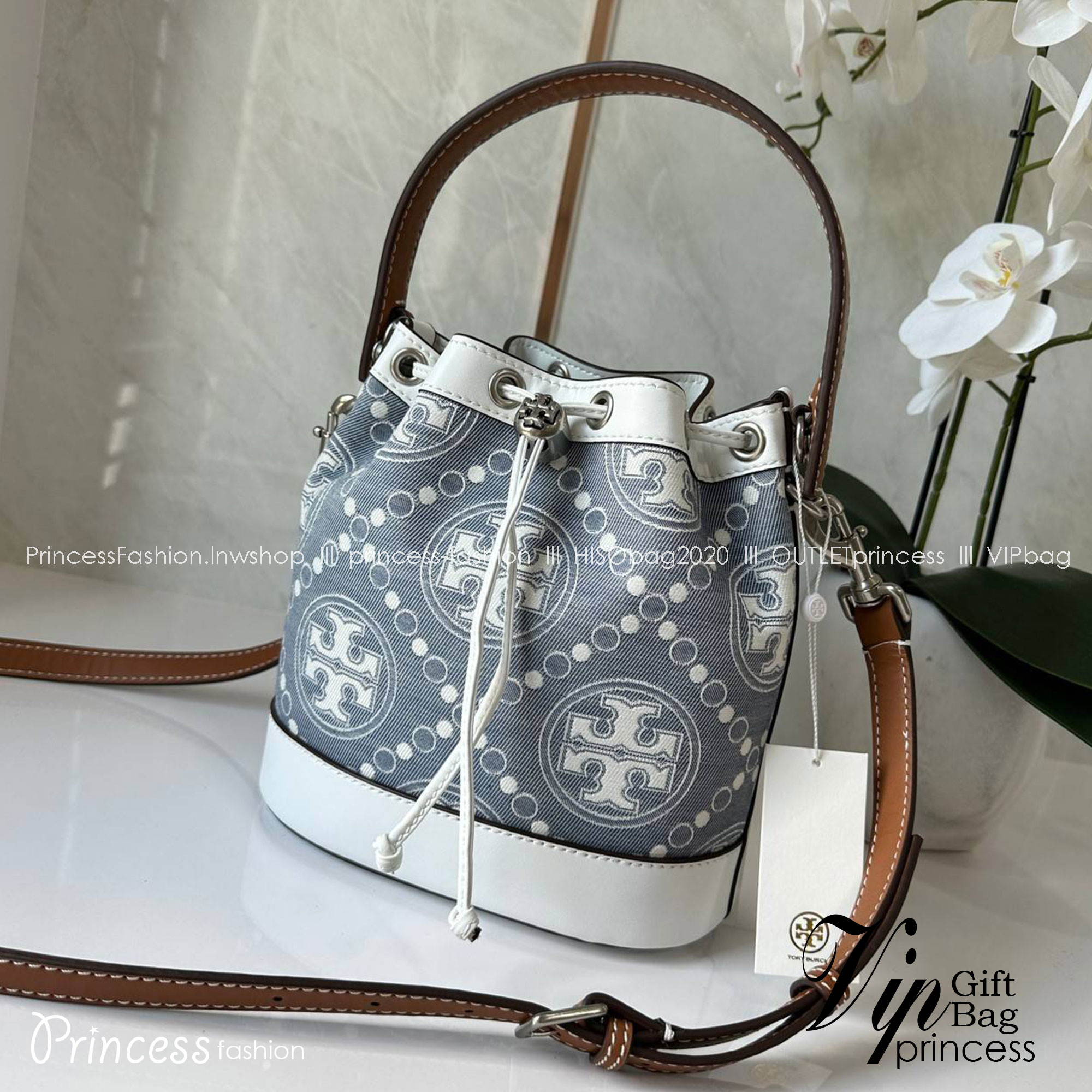 TORY BURCH T Monogram Denim Bucket Bag MEDIUM คอลเลคชั่นใหม่ รูปแบบคลาสสิค พกพาความหรูหราไปได้ทุกที่ด้วยกระเป๋าทรง Bucket ขนาดกลางและปิดด้วยเชือกรูดพร้อมโลโก้แวววาว วัสดุผ้าเดนิมแจ็คการ์ด ตัดขอบหนังแท้