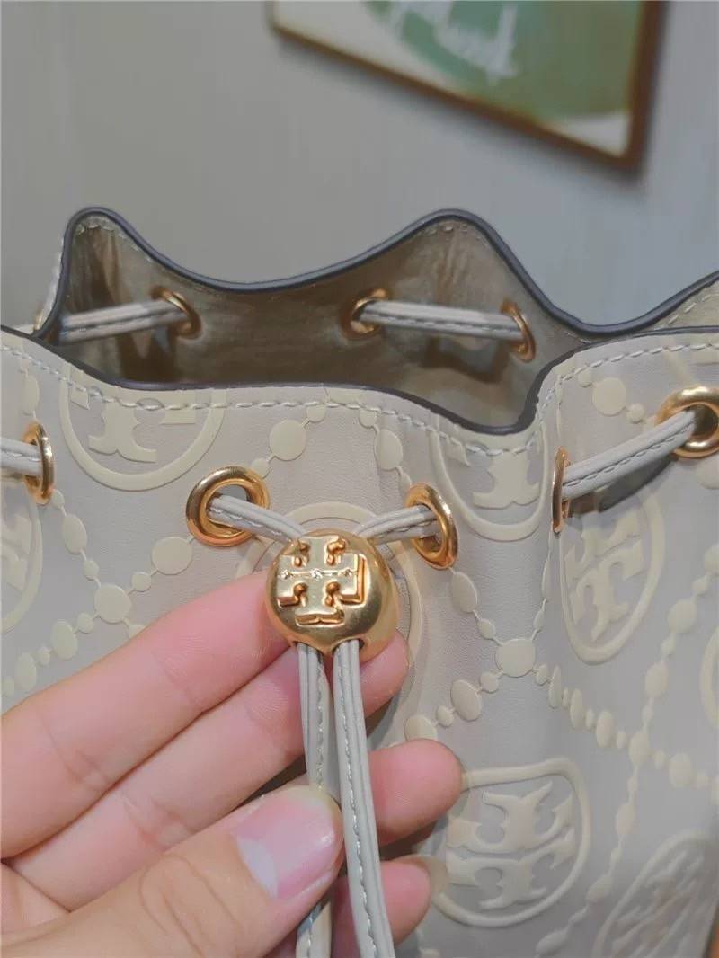 Medium : Tory Burch T Monogram Embossed Bucket Bag กระเป๋าถือหรือสะพายไหล่ ประดับด้วยลวดลายอันเป็นสัญลักษณ์ของแบรนด์ ถูกประดิษขึ้นด้วยความพิถีพิถันวัสดุหนังอย่างดี ด้านในบุด้วยหนังไมโครซูแอคเนื้อนุ่มทำความสะอาดง่าย กระเป๋าผ่าหลังด้านนอก1ช่อง ด้านใน 1ช่อง 