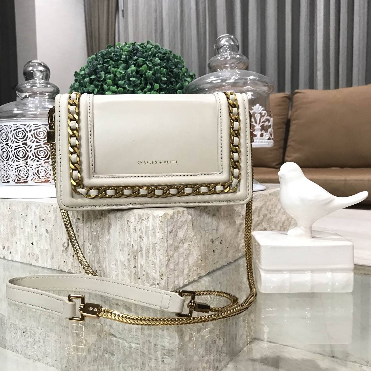 NEW ARRIVAL! CHARLES & KEITH CHAIN DETAIL CROSSBODY BAG กระเป๋าสะพายทรงสี่เหลี่ยมรุ่นชนช็อปขนาดกำลังดีวัสดุหนังนิ่มเรียบประดับด้วยโซ่ด้านหน้าดูมีดีเทล เปิดปิดด้วยกระดุมแม่เหล็ก ภายในมีช่องใส่บัตรและช่องซิป มาพร้อมสายโซ่ต่อหนังถอดถือเป็นคลัชได้ ภาพถ่ายสินค