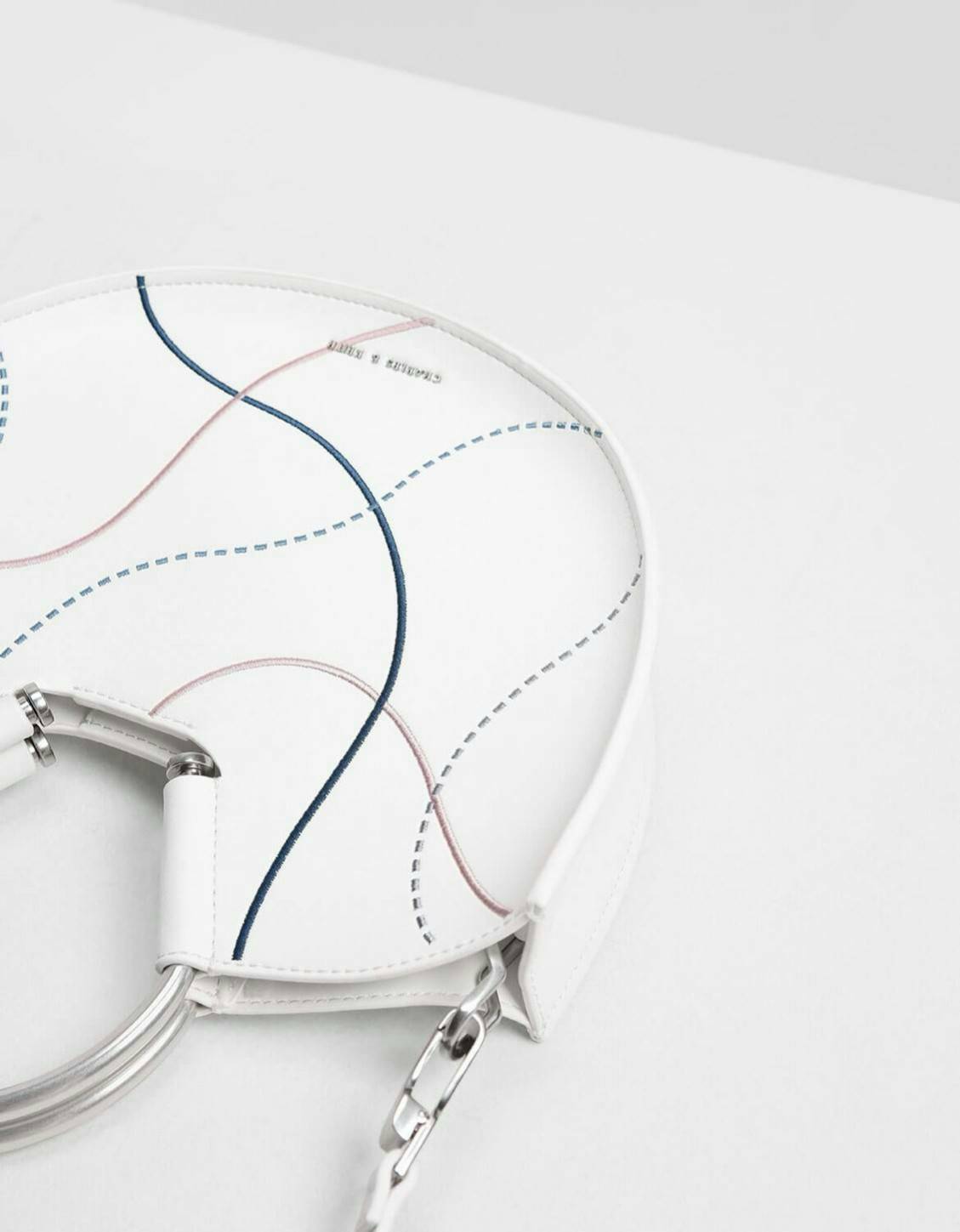 CHARLES & KEITH รุ่น U SHAPE TOP HANDLE BAG CK2-30780786_WHITE ราคาปกติช้อป ( ฿2,590.00 ) กระเป๋าทรงโค้งรูปตัว U วัสดุหนัง PU ลงแพทเทิร์นลวดลาย เส้นด้ายปักแต่งสีสัน บนตัวกระเป๋า เพิ่มความสวยสะดุดตา รับประกันความเก๋!! จะทำให้คุณโดดเด่นไม่เหมือนใคร หูกระเป๋