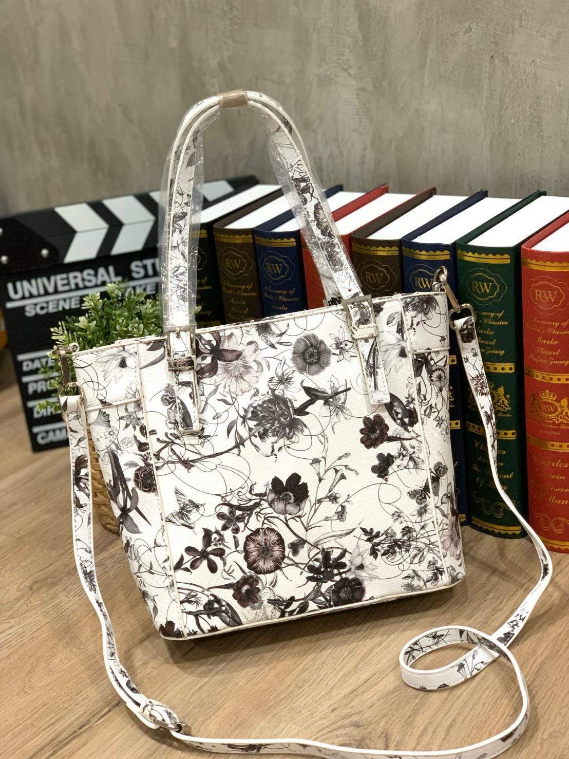GUESS Women's Medium Floral Tote Bag กระเป๋าถือ คล้องไหล่หรือสะพาย ขนาดกลาง วัสดุหนังpu ลายดอกไม้ชนิดต่างๆรอบใบ เปิดปิดใช้งานด้วยซิปเดียวด้านบน ภายในมีกว้างใส่กระเป๋าสตาวค์ยาว มินิไอแพคได้ หูจับและสายสะพายปรับระดับได้ มาพร้อมกุญแจโลโก้guess สวยน่ารัก