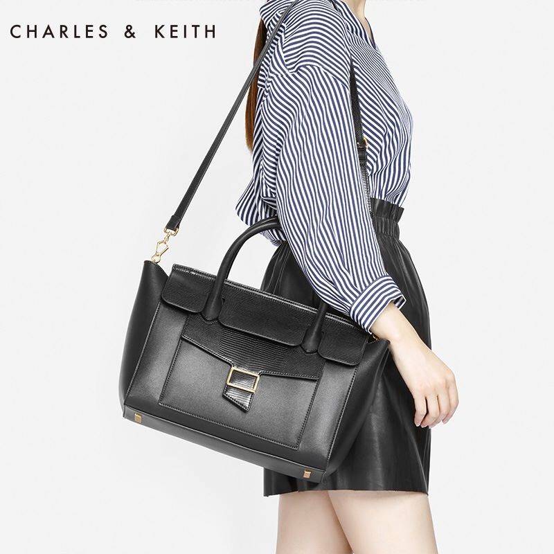 CHARLES & KEITH OVERSIZED TOP HANDLE BAG (Black) กระเป๋าถือใบใหญ่หนังเรียบสวยหรู กระเป๋าถือพร้อมสายสะพายไหล่ ปรับสายได้ค่ะ ด้านหน้ามีช่องเก็บของออกแบบเหมือนเข็มขัด เปิดปิดกระเป๋าด้วยกระดุมแม่เหล็ก อะไหล่สีทอง มีหมุดรองฐานกระเป๋า ด้านในมีช่องซิป 1 ช่อง