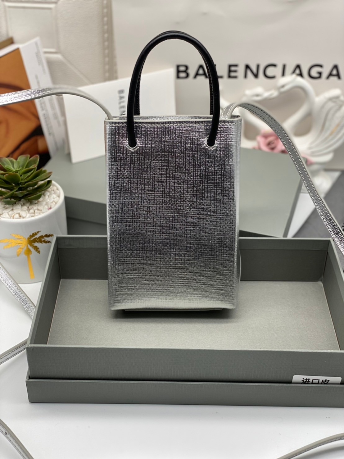 หนังแท้ BALENCIAGA Shopping Phone Pouch leather tote พกกระเป๋าช้อปปิ้งขนาดมินิ ไปทุกที่ในฤดูกาลนี้ ดีไซน์ที่ใช้ได้ทุกวันตั้งแต่หนังแบบมีเท็กซ์เจอร์ ภาพสินค้าถ่ายจากงานขายจริง ใช้งานต่างประเทศได้