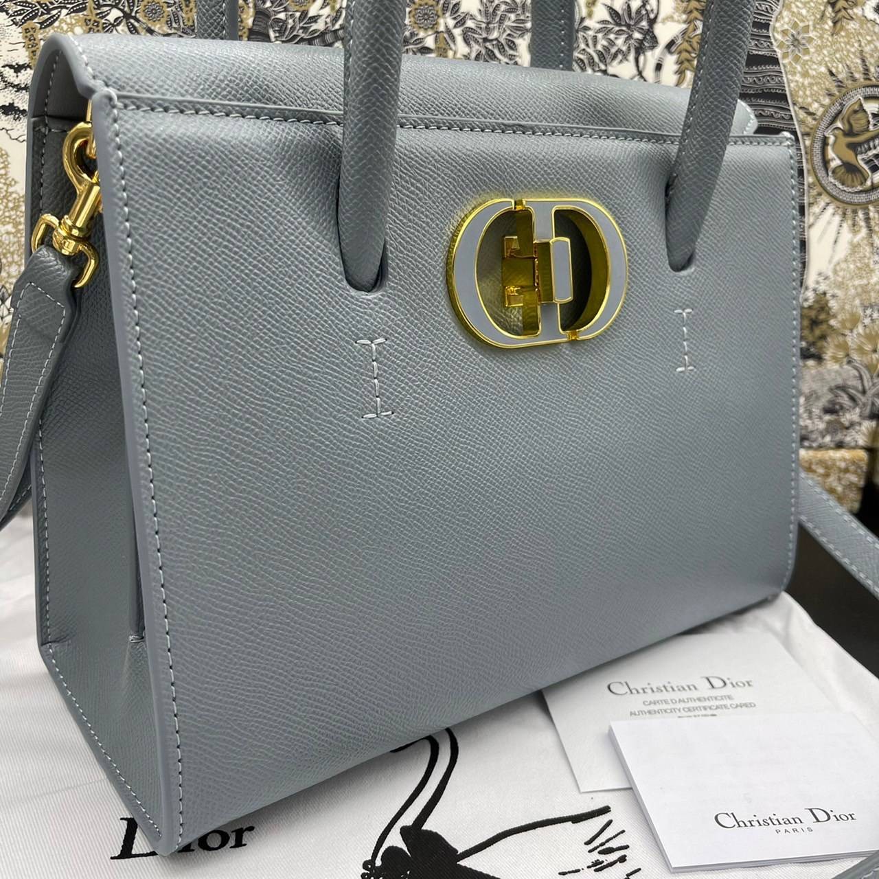 หนังแท้ DIOR Medium ST Honore Tote Collection Fall/Winter 2020-2021 มาในรูปแบบกระเป๋าทรงสี่เหลี่ยมที่ได้มาตรฐาน ทำจากหนังลูกวัว (Calfskin) ลายเกรน ซึ่งสื่อถึงความหรูหราได้อย่างลงตัว ตัวด้ามจับ มีการเย็บเข้าด้านในของกระเป๋าเพื่อเพิ่มความแข็งแรงทนทาน ด้านหน