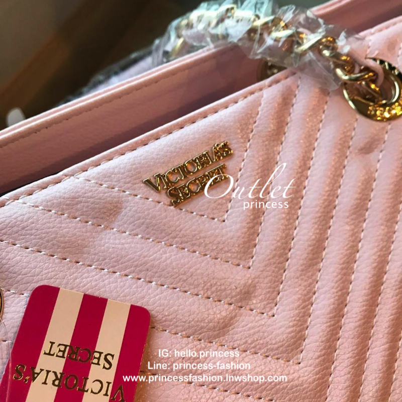 Victoria’s Secret Quileted Tote Bag กระเป๋าถือหรือสะพายลายหนังแกะสังเคราะห์อยู่ทรงสวย ดีไซน์ลายริ้วเป็นตัววี ด้านหน้าประดับด้วยโลโก้อะไหล่ทอง เปิดปิดด้วยซิปเดียว ภายในมีช่องโล่งและช่องเล็กไว้แบ่งเก็บของ ใส่หนังสือ เอกสาร A4 Notebook ipad กระเป๋าสตางค์ ของ