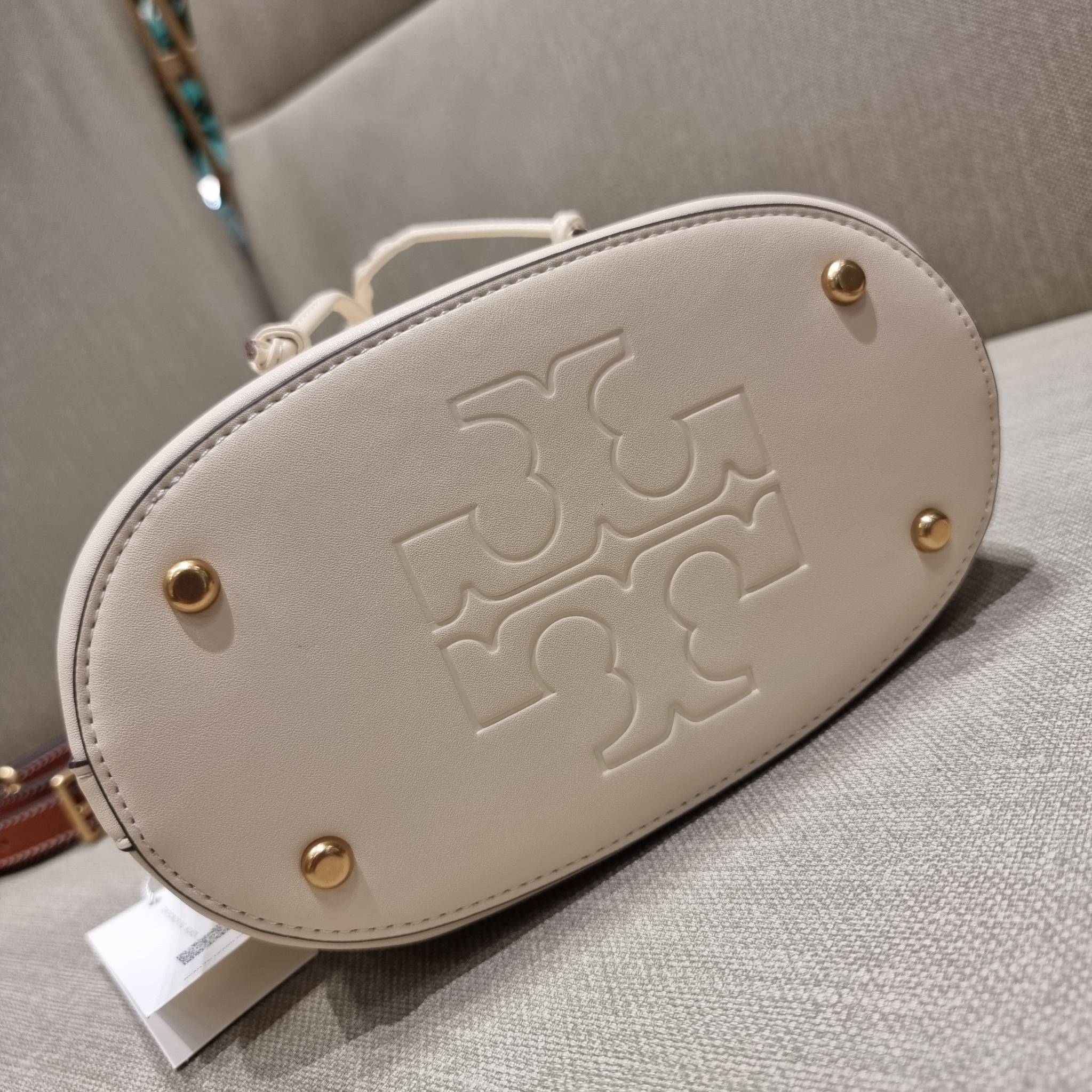 TORY BURCH T MONOGRAM EMBOSSED BUCKET BAG คอลเลคชั่นใหม่ กับกระเป๋าบัคเก็ตทรงยอดนิยม ดีไซน์ใหม่ล่าสุด สวยลูกคุณหนู หรูหรา!! ด้วยดีเทลผิวลายนูนลวดลายเอกลักษณ์ วัสดุหนังแท้ ปากกระเป๋ารูดเปิด-ปิดได้ มีหูจับในตัว สะดวกใช้ไปอีก และมีสายสะพายข้าง ปรับได้อีกด้วย