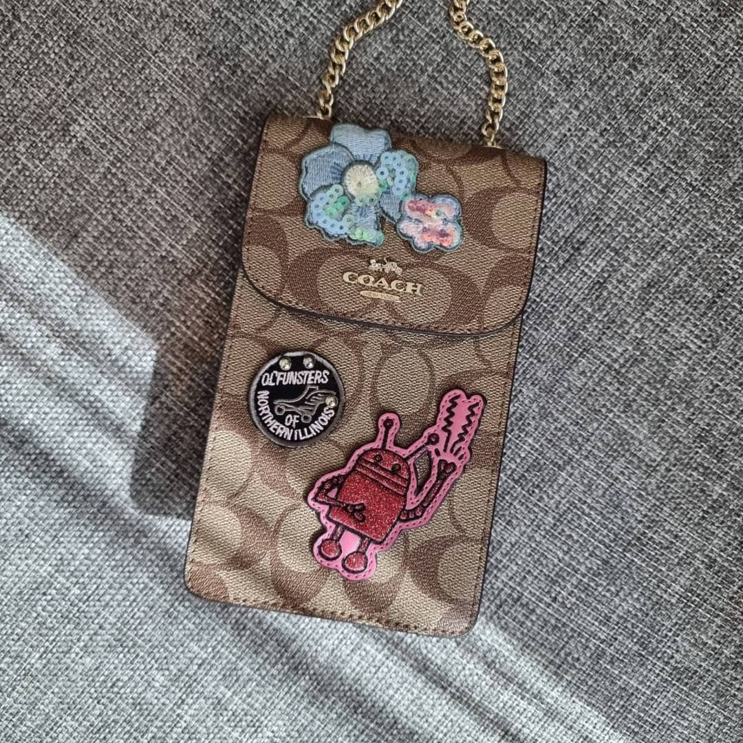 COACH NORTH/SOUTH PHONE CROSSBODY IN SIGNATURE CANVAS F55636 F39955 สุดคลาสสิคกับกระเป๋าสะพายเอนกประสงค์ Case phone ใส่โทรศัพท์มือถือได้ทุกรุ่น ดีไซน์ลายเอกลักษณ์ วัสดุหนังแคนวาสเคลือบลาย ฝาและภายในเป็นหนังสังเคราะห์เรียบ เปิด-ปิดด้วยกระดุม สายสะพายยาวประ