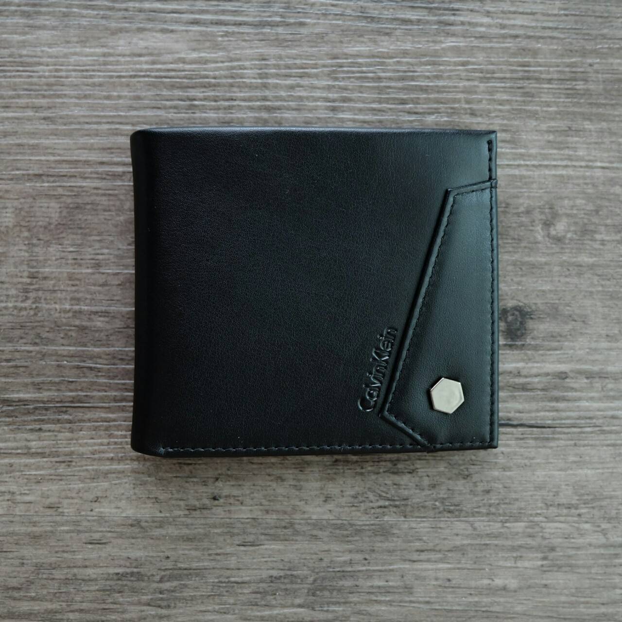 Calvin Klein Short Wallet กระเป๋าสตางค์ใบสั้น ด้านหน้ามีโลโก้แบรนด์ และตกแต่ง ด้วยหมุดโลหะเงิน ภายในมีช่องใส่ธนบัตร ช่องใส่บัตรหลาย ช่อง และช่องใส่รูป จะมอบเป็นของขวัญหรือใช้เองก็แนะนำค่ะ