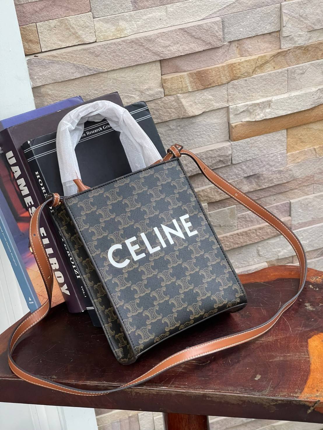 CELINE MINI VERTICAL CABAS IN TRIOMPHE CANVAS มีโลโก้ CELINE สกรีนอยู่ตรงกลาง ถือเป็นกระเป๋า Tote ที่ทำจากแคนวาสที่น่าสนใจมาก ๆ อีกรุ่นหนึ่ง และเป็นรุ่นที่ได้รับคำชื่นชมจากแฟชั่นกูรูทั้งหลายอีกด้วย หากใครที่อยากเป็นเจ้าของกระเป๋า Tote จาก CELINE สักใบ รุ่