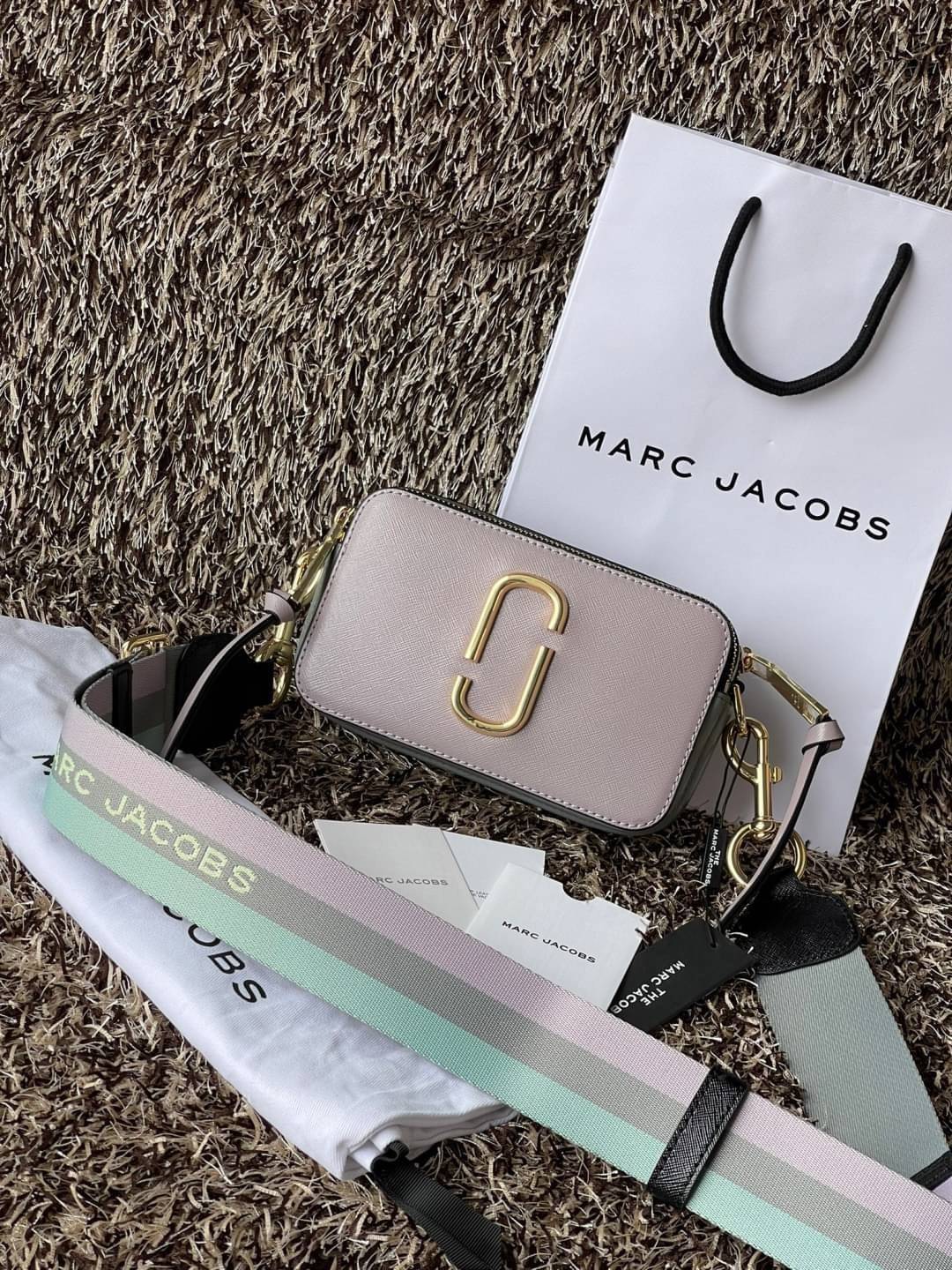 Marc Jacobs Snapshot Bag กระเป๋าแบรนด์ดังจากสัญชาติอเมริกัน นับได้ว่ารุ่นนี้เป็นรุ่นทรงฮิตเลยทีเดียว โดยด้านหน้ากระเป๋าจะเป็นโลโก้แบบโลหะที่เป็นสัญลักษณ์ของแบรนด์นี้ มาพร้อมสายสะพายที่จะสะพายยังไงก็ดูโดดเด่น เพราะขนาดใหญ่ที่สกรีนตัวอักษรโลโก้ ในรูปแบบต่าง