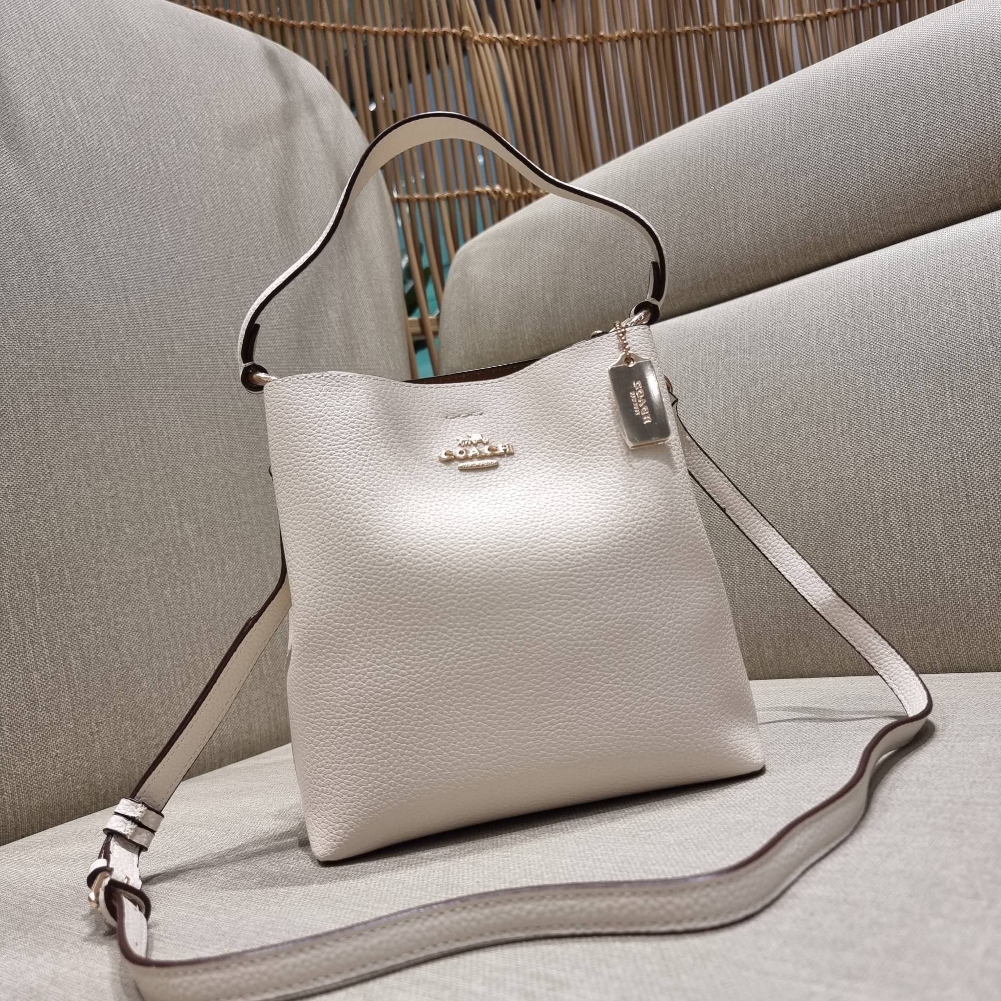 COACH 1011 SMALL TOWN BUCKET BAG รุ่นยอดนิยมใบเล็ก กระเป๋าทรงบัคเก็ต สีคลาสสิคเรียบหรู ตัดกับโลโก้สีทองดูโดดเด่น วัสดุหนัง pepble สวยคมทุกมุมจริงๆ!! เปิด-ปิดด้วยกระดุมแม่เหล็กทั้ง 2 ฝั่ง ภายในเป็นช่องโล่ง มาพร้อมสายสะพายปรับได้ตามตัว ขนาดใบนี้กำลังสวย สะพ
