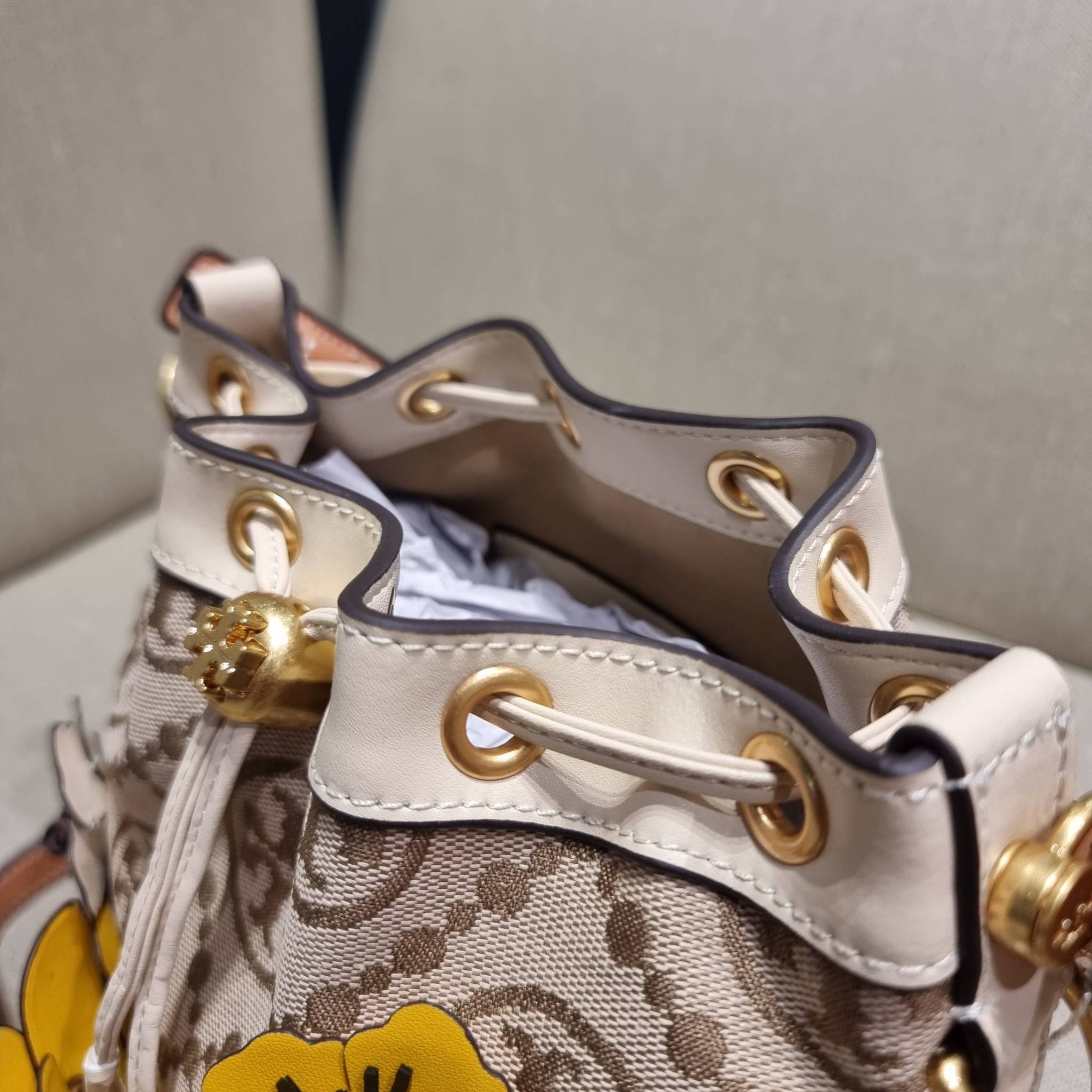 TORY BURCH T MONOGRAM FLORAL BUCKET BAG คอลเลคชั่นใหม่ พร้อมเสิร์ฟความสวยให้ถึงบ้าน!! กระเป๋าบัคเก็ตทรงยอดนิยม ดีไซน์ใหม่ล่าสุด สไตล์งานคราฟ มีลูกเล่นประดับดอกไม้กับตัวกระเป๋า และตัวรูดสาย วัสดุผ้า jacquard ตัดสลับหนังแท้ หูจับและขอบกระเป๋าตกแต่งลายสานสวย