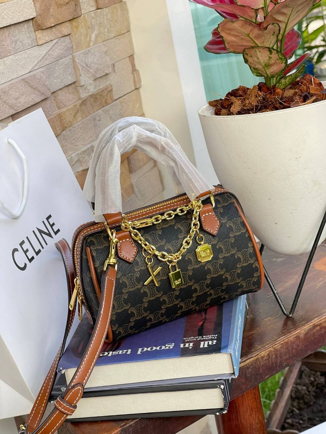 CELINE MINI BOSTON BAG IN TRIOMPHE CANVAS กระเป๋าทรงหมอนขนาดกะทัดรัด เป็นทรงฉิตตบอดกาลไม่มีเอ้าท์ ถือหรือสะพายได้อย่างคล่องตัว ภายในสามารถบรรจุสิ่งของที่จำเป็น สิ่งที่โดดเด่นของกระเป๋าหนังลาย Triomphe ที่ได้รับความนิยมอย่างแพร่หลาย มีอะไหล่ทองประดับเพิ่มม