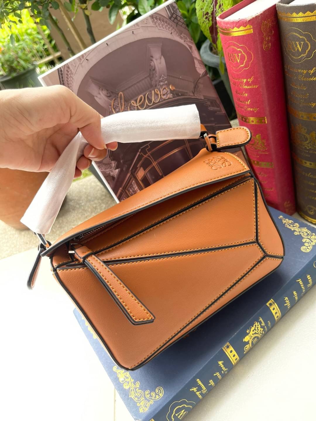 Loewe Nano Puzzle bag in classic โลเอเว่ (LOEWE) อีกหนึ่งกระเป๋าแบรนด์ดังจากสเปน ภายใต้คอลเลคชั่นใหม่อันร่วมสมัยของแบรนด์ มีความเป็นคลาสสิคและโมเดิร์นทันสมัย กระเป๋าที่มาในรูปแบบสี่เหลี่ยมผืนผ้า ที่สามารถใช้งานได้ทั้งแบบหูหิ้ว และแบบ Crossbody ด้านในมีช่อ