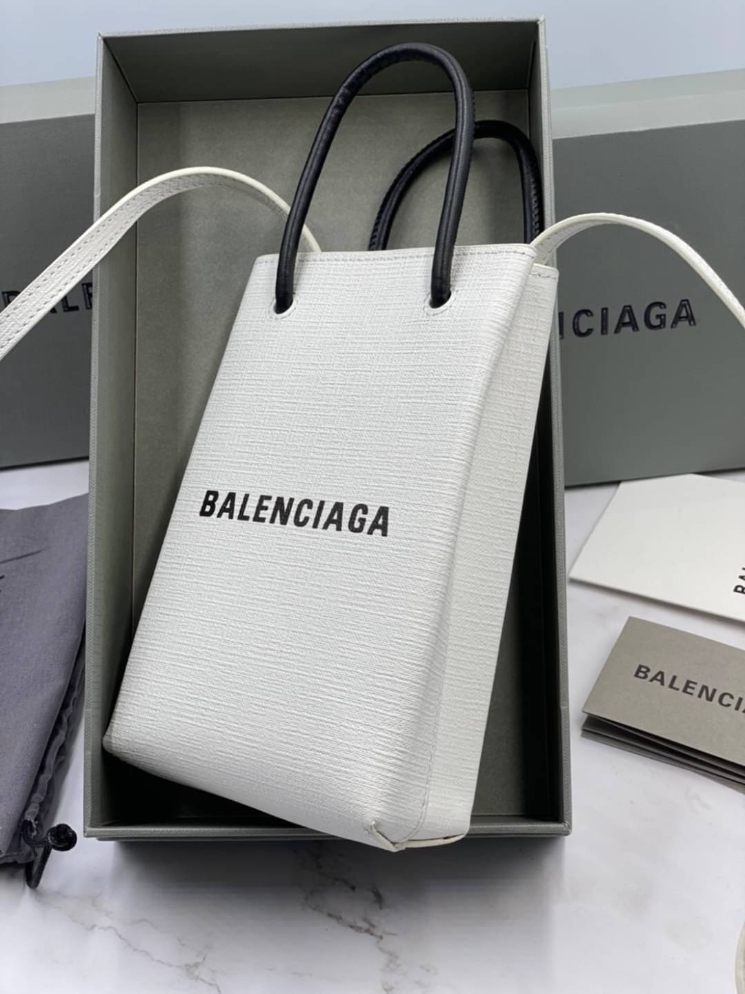 หนังแท้ BALENCIAGA Shopping Phone Pouch leather tote พกกระเป๋าช้อปปิ้งขนาดมินิ ไปทุกที่ในฤดูกาลนี้ ดีไซน์ที่ใช้ได้ทุกวันตั้งแต่หนังแบบมีเท็กซ์เจอร์ ภาพสินค้าถ่ายจากงานขายจริง ใช้งานต่างประเทศได้