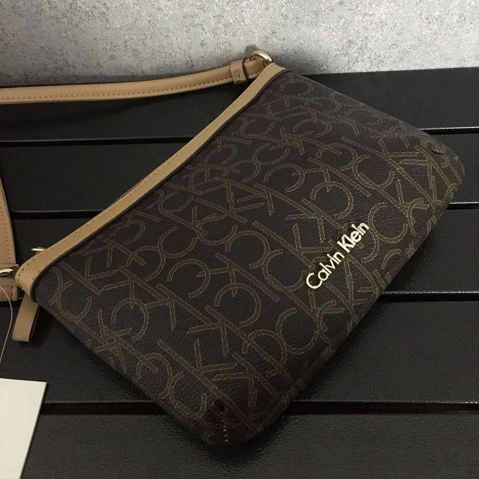 Calvin Klein Cross Body Bag กระเป๋าสะพายรุ่นใหม่ล่าสุดหนังสวย สกรีนลาย Signature แบรนด์รอบใบ ประดับโลโก้แบรนด์ สีทองด้านหน้า เปิดปิดด้วยซิป น้ำหนักเบา ภายใน โล่งกว้าง มีช่องใส่บัตร และช่องซิป ใส่ iphone+ ได้ มาพร้อมสายสะพายยาว ขนาดกำลังน่ารัก สะพายคล่องตั