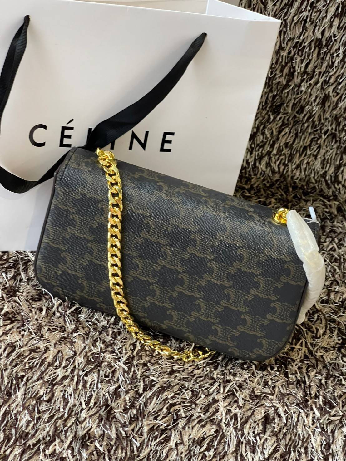 Celine Chain Shoulder Bag Cuir Triompe In Triompe เป็นกระเป๋าถูกประดิษฐ์ขึ้นในรูปทรงมินิมอล นับว่าเป็นกระเป๋าอีกหนึ่งรุ่นในซีรีส์ Triomphe ที่ได้รับความนิยมอย่างมาก โดยเป็นกระเป๋าสะพายไหล่ทรงสี่เหลี่ยมผืนผ้าที่อัดแน่นไปด้วยกลิ่นอายความคลาสสิกตามแบบฉบับของ