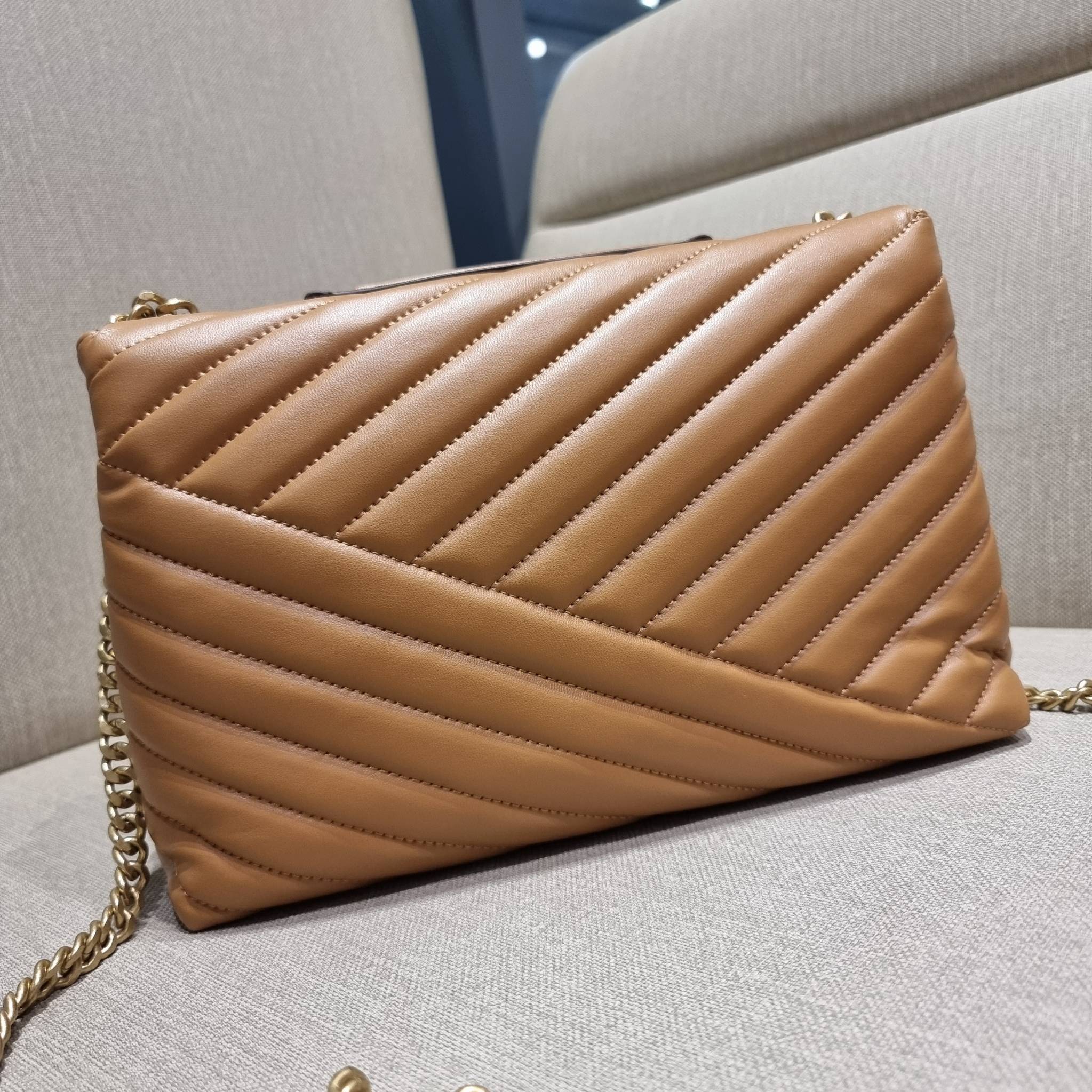 TORY BURCH KIRA CHEVRON CONVERTIBLE SHOULDER BAG กระเป๋าสะพายรุ่นยอดฮิต ไซส์ใหญ่จัดเต็มให้เน้นๆ ใช้ยังไงก็ดูหรู ดีไซน์เฉพาะตัว วัสดุหนังแกะ สัมผัสนิ่ม เปิด-ปิดด้วยกระดุมแม่เหล็ก ภายในเป็นช่องโล่ง แบ่งสัดส่วนไว้ดีมากๆ ใส่กระเป๋าสตางค์ มือถือ เครื่องสำอางค์