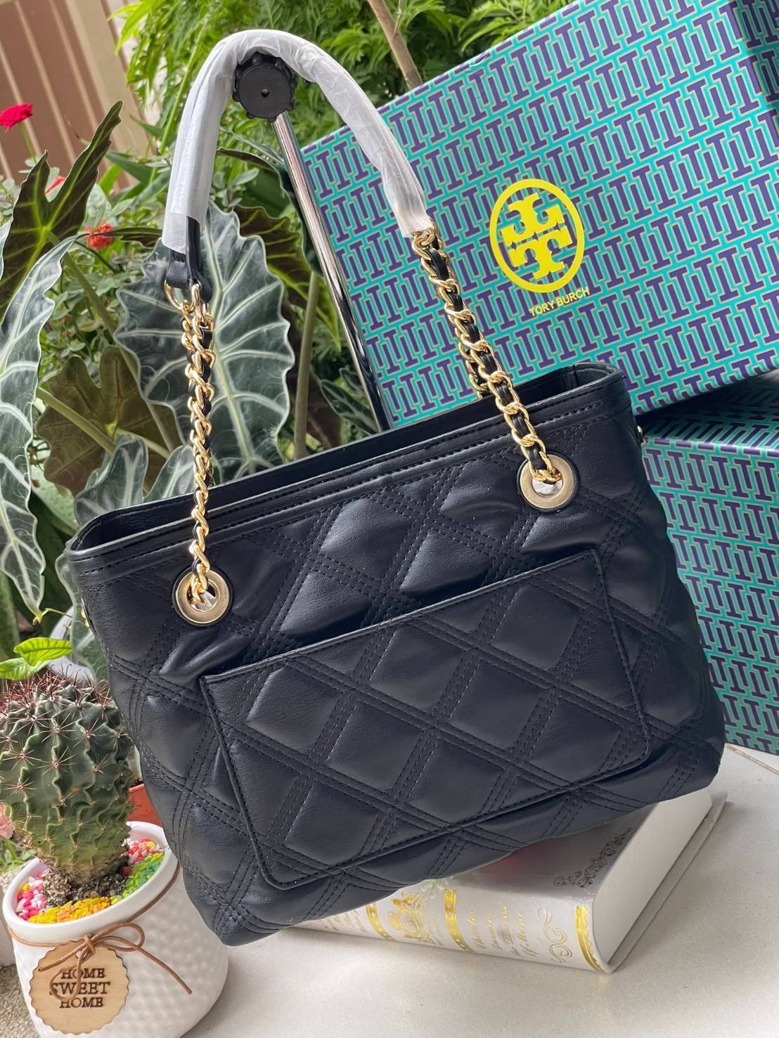 Tory Burch Fleming Soft Small Tote Bag เป็นกระเป๋าสะพายไหล่น่ารัก ๆ สักใบที่มีดีไซน์โดดเด่น สะดุดตา ใน Collection เรียกได้ว่าขายดีอันดับต้น ๆ ของแบรนด์ ใช้ได้ในลุคช์ทางการและกึ่งทางการ ดีเทลการตัดเย็บพิมพ์ลายนูนคู่กับแพทเทิร์นสี่เหลี่ยมทรงเพชร ที่ช่วยเพิ่