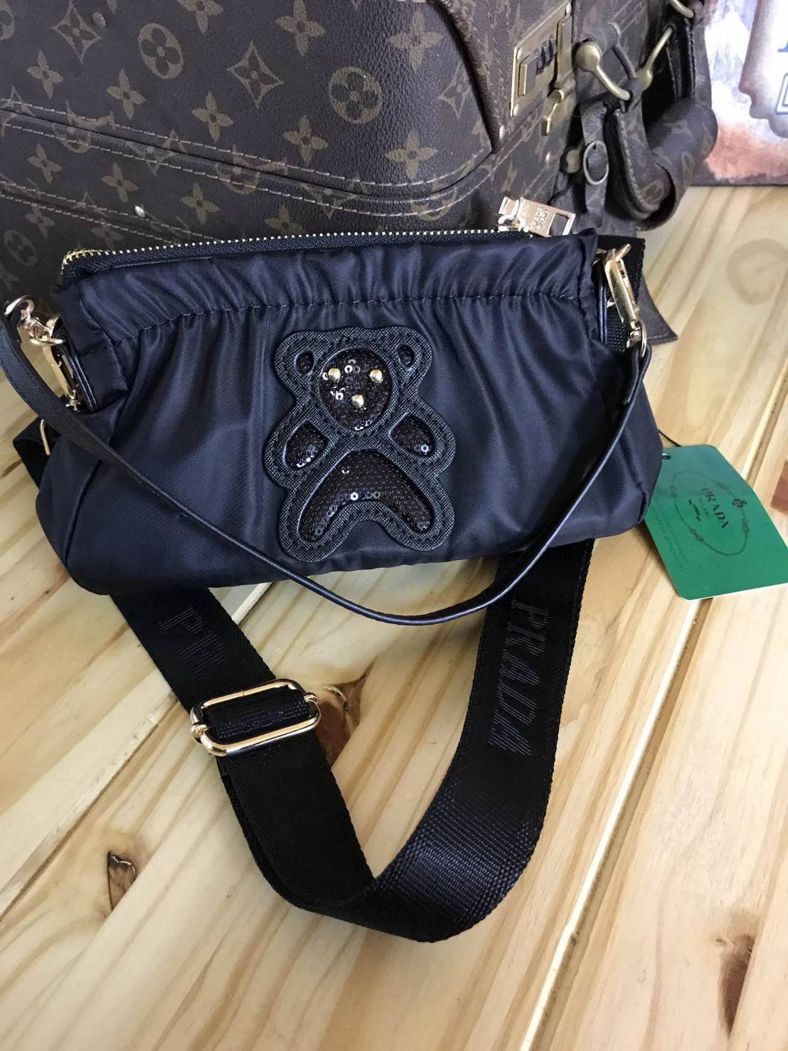 Don't Miss! PRADA NYLON CROSSBODY BAG กระเป๋าสะพายพรีเมี่ยมกิ้ฟจากเคาน์เตอร์ต่างประเทศรุ่น Limited edition วัสดุเป็น Nylon เนื้อหนาคุณภาพดีตามแบบฉบับของแบรนด์ ขนาดกำลังดี ด้านหน้าเป็นลายหมีปั๊กกลิ้ตเตอร์อะไหล่ทองสวยภายในซับ Polyester 100% สกรีนโลโก้แ