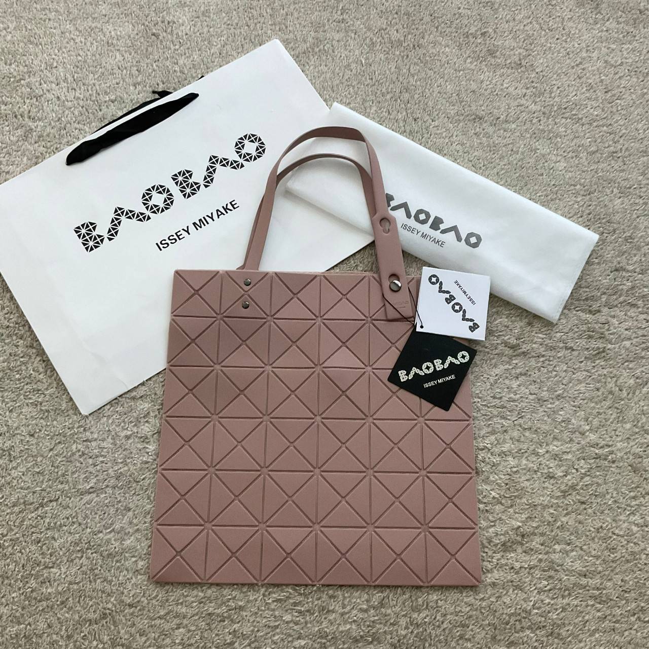 BAO BAO ISSEY MIYAKE LUCENT ONE-TONE กระเป๋าสะพายไหล่ ทรงโท้ท ใบใหญ่สวยมาก ปรับได้หลายทรงตามเอกลักษณ์เฉพาะของแบรนด์นี้ วัสดุ 100% POLYESTER PARTLY: SYMYHETIC LEATHER ด้านในใส่ของได้เยอะมาก ใส่ไอแพด สมุดโน้ตได้สบายเลย วัยทำงานหรือวัยนักศึกษา อย่างน้อยต้องม