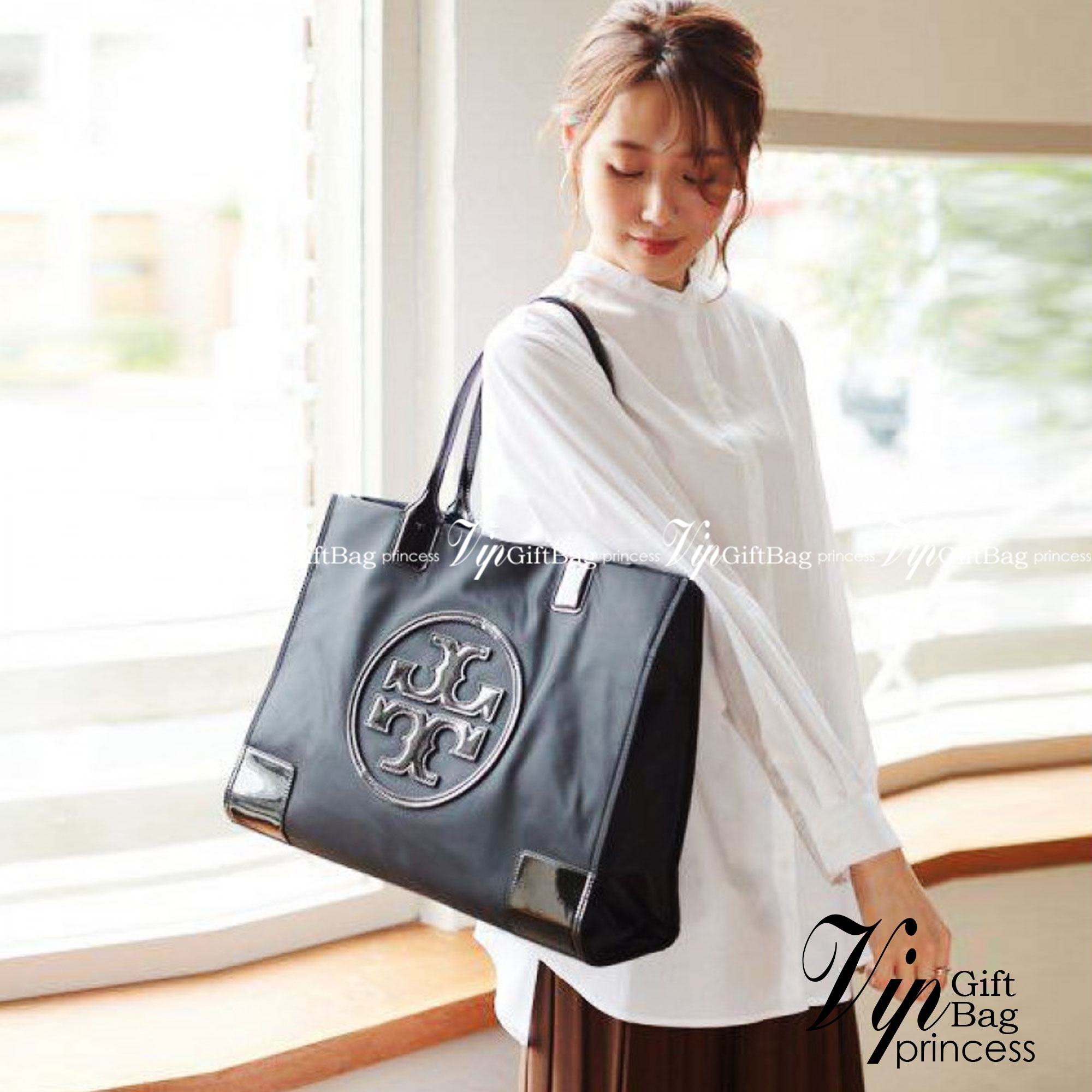 กระเป๋าทรงโท้ทใบใหญ่ TORY BURCH ELLA TOTE BAG วัสดุ NYLON ทั้งใบตัดด้วยหนังสีดำ แต่งโลโก้แบรนด์ด้านหน้า ด้านข้างมีกระดุม สามารถขยายทรงได้ ด้านในเปิดปิดด้วยกระดุมแม่เหล็กฝัง ช่องกว้างหลักหนึ่งช่องและช่องซิปอีกช่อง สามารถใส่แล็ปท็อปได้สบาย ใบใหญ่เว่อวัง ไอเ
