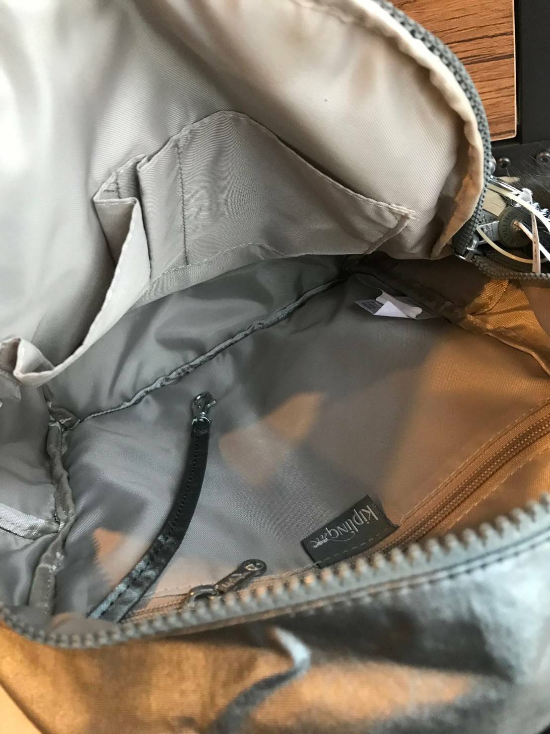 Kipling Matta Small Metallic Backpack กระเป๋าเป้ขนาดกำลังดี วัสดุไนล่อนเคลือบกันน้ำ มีน้ำหนักเบา มีช่องเก็บของหลายช่อง แบ่งเป็นช่องด้านหน้า 2 ช่องและด้านข้างอีก 2 ช่อง ช่องใหญ่ปิดเปิดด้วยซิปคู่ภายในมีช่องซิป ช่องใส่ของจุกจิกและสายห้อยพวงกุญแจ ด้านหน้าประด