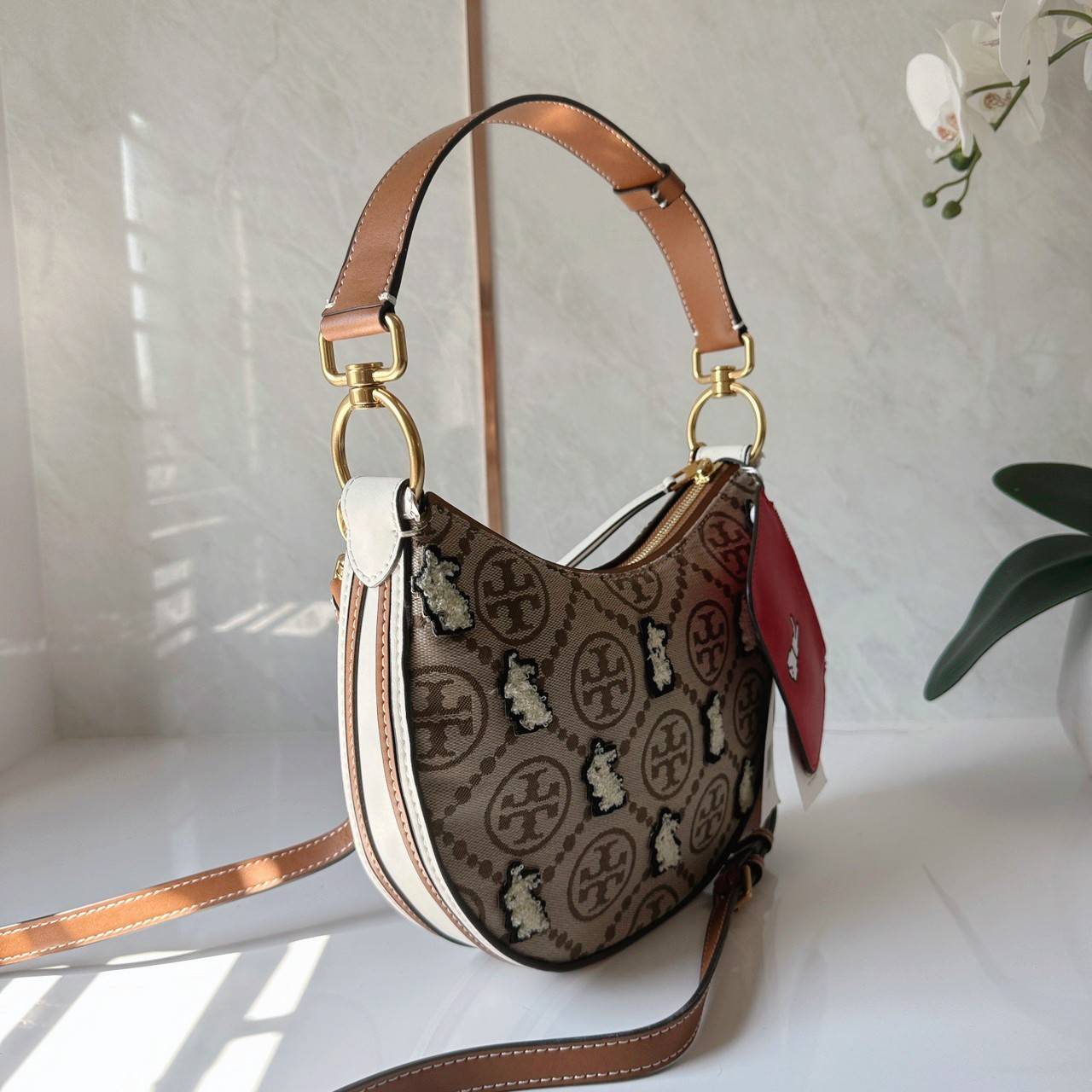 TORY BURCH Mini T Monogram Embroidered Rabbit Crescent Bag 🐇 คอลเลคชั่นกระต่ายสุดร้อนแรงแห่งปี 🥕🥕 คอลเลคชั่นทีบ่งบอกสไตล์ที่ทันสมัยทรงครึ่งวงปักลายกระต่ายบนกระเป๋าสุดน่ารัก โด่ดเด่น