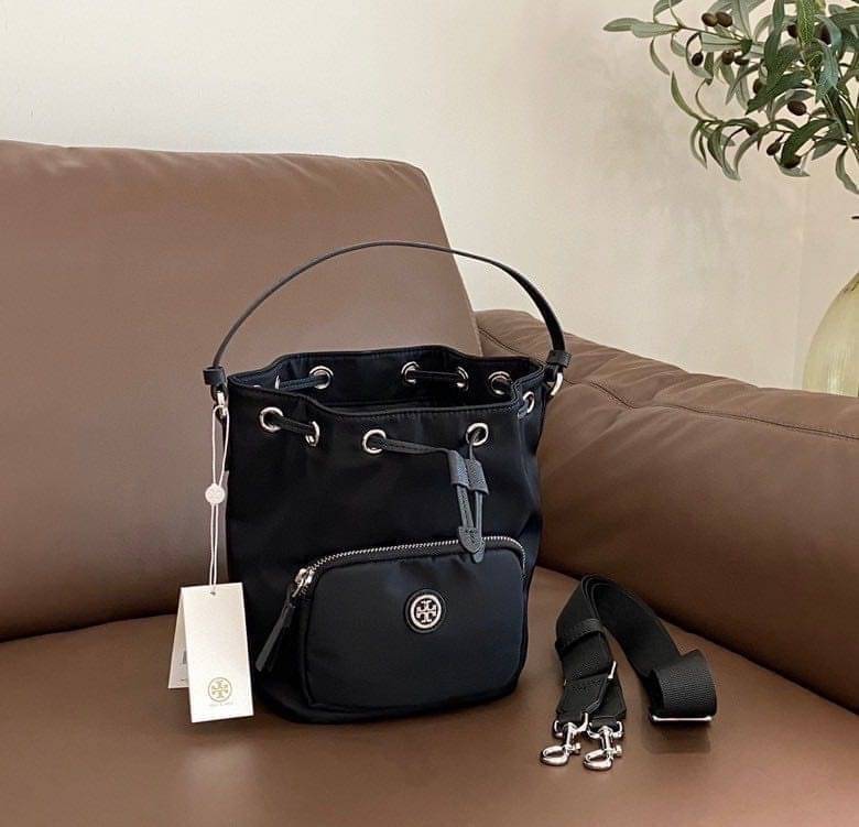 Tory Burch Virginia Nylon Bucket Bag / Tory Burch logo-plaque bucket bag กระเป๋าสะพายทรงบัคเก็ต เปิด-ปิดหนังรูดปากกระเป๋า มีหูหิ้วในตัว คล้องแขนเก๋ๆ ภายในเป็นช่องโล่ง มีช่องย่อย ใส่ของสำคัญจุกจิกได้ มีสายครอส จะสะพายไปไหนก็ได้ทุกโอกาส สวยเลิศทุกสี พร้อมส่
