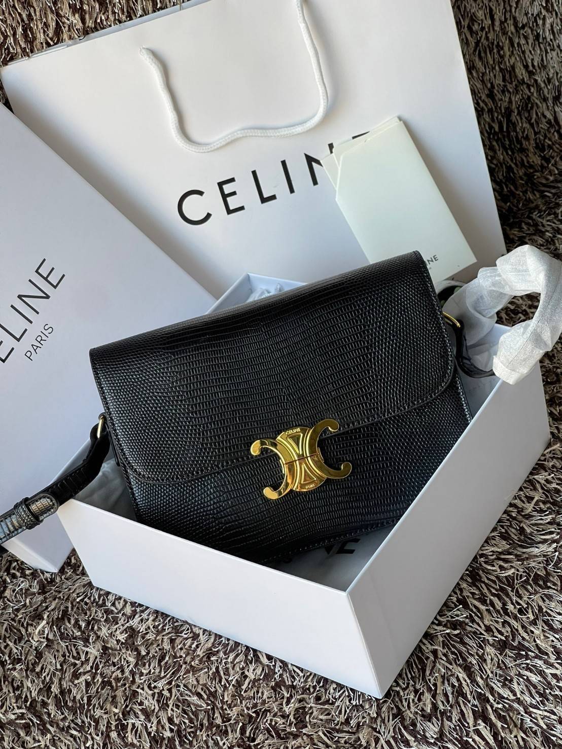 Celine MEDIUM TRIOMPHE BAG IN SHINY By croc มีรูปทรงเป็นกล่องคล้ายกับกระเป๋า Classic Box แต่มีการออกแบบโลโก้ที่สะดุดตาแบบวินเทจ ด้วยดีไซน์หรูหราและที่ดูโฉบเฉี่ยวเ้วยลงดลายcroc มีความคลาสสิคอย่างเต็มเปี่ยม ทำให้เป็นที่ดึงดูดความสนใจของสาวๆ ด้วยความคล่องตัว