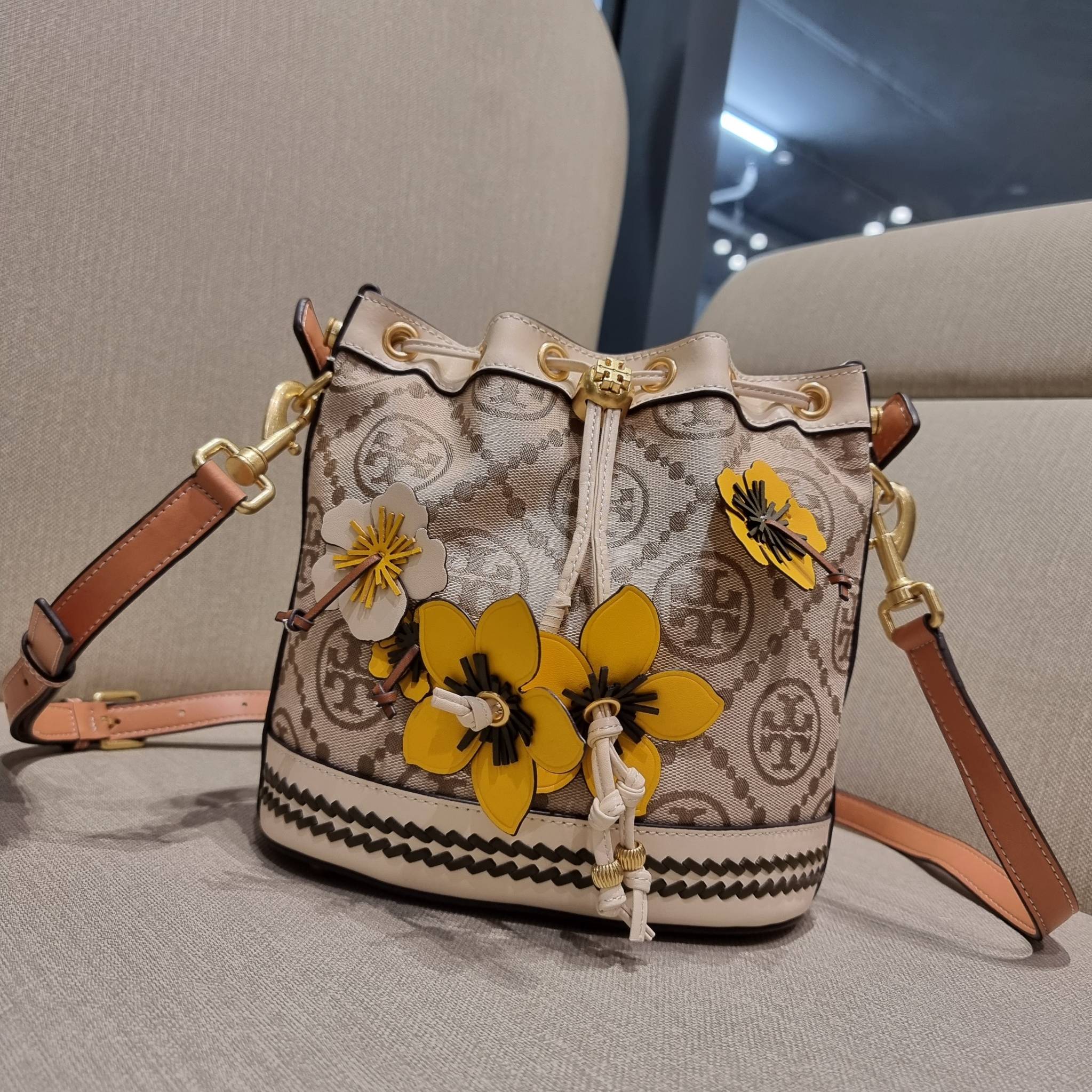 TORY BURCH T MONOGRAM FLORAL BUCKET BAG คอลเลคชั่นใหม่ พร้อมเสิร์ฟความสวยให้ถึงบ้าน!! กระเป๋าบัคเก็ตทรงยอดนิยม ดีไซน์ใหม่ล่าสุด สไตล์งานคราฟ มีลูกเล่นประดับดอกไม้กับตัวกระเป๋า และตัวรูดสาย วัสดุผ้า jacquard ตัดสลับหนังแท้ หูจับและขอบกระเป๋าตกแต่งลายสานสวย