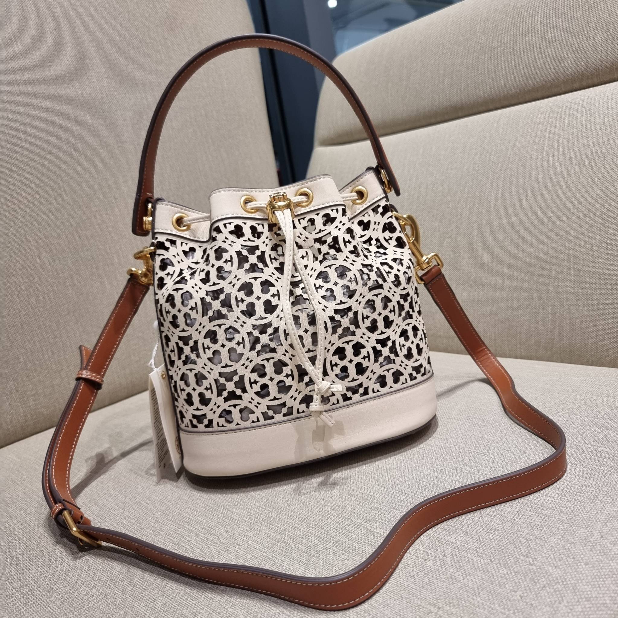 TORY BURCH T MONOGRAM LASER-CUT BUCKET BAG ใจบางที่สุดกับคอลเลคชั่นนี้ กับกระเป๋าสะพายทรงบัคเก็ต รุ่นชูโรงสุดฮิต ที่เพิ่มดีเทลความแพงด้วยการฉลุลวดลายโมโนแกรมรอบใบ ถักทอเป็นเส้นลายสานที่สวยงามมาก งานฝีมือจริงๆ วัสดุหนัง cowhide รูดเปิด-ปิดด้วยเส้นหนัง มาพร