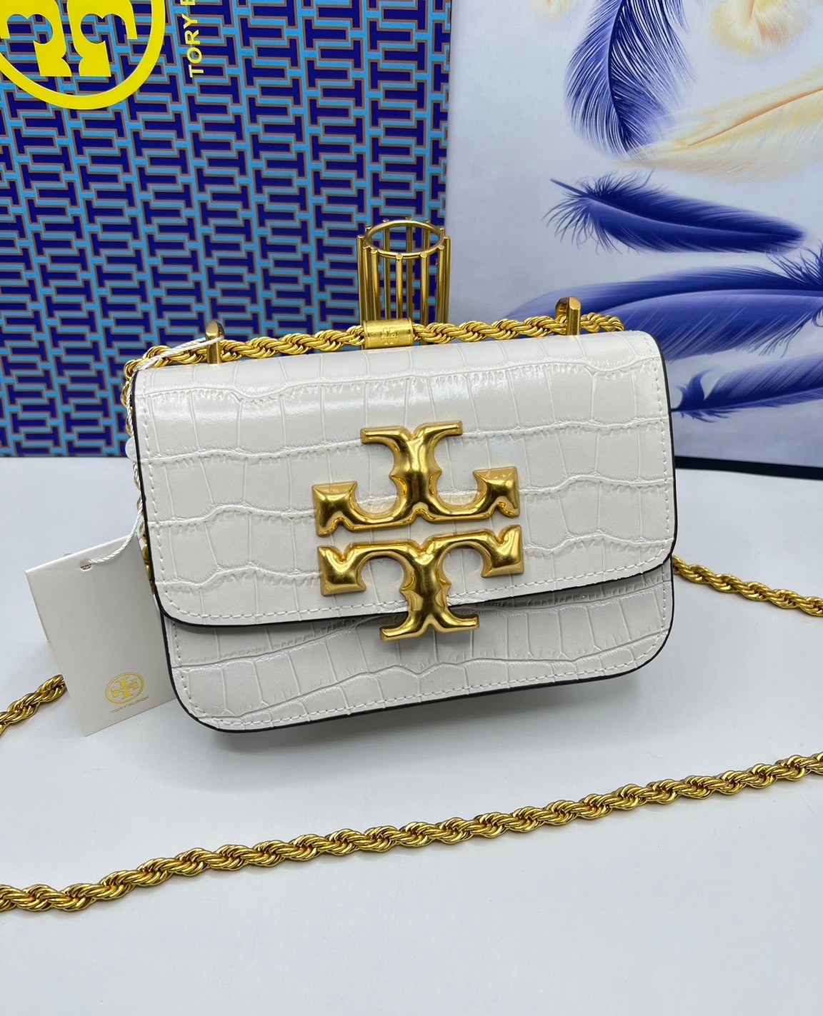 6 สี Tory Burch Croc Eleanor Small Bag / TORY BURCH ELEANOR CROC EMBOSSED LEATHER กระเป๋าสะพายหนังพิมพ์ลายจระเข้ ดีไซน์หรูหรา โด่นเด่นด้วยโลโก้แบรนด์อะไหล่ด้านหน้า และสายสะพายโลหะสีทอง