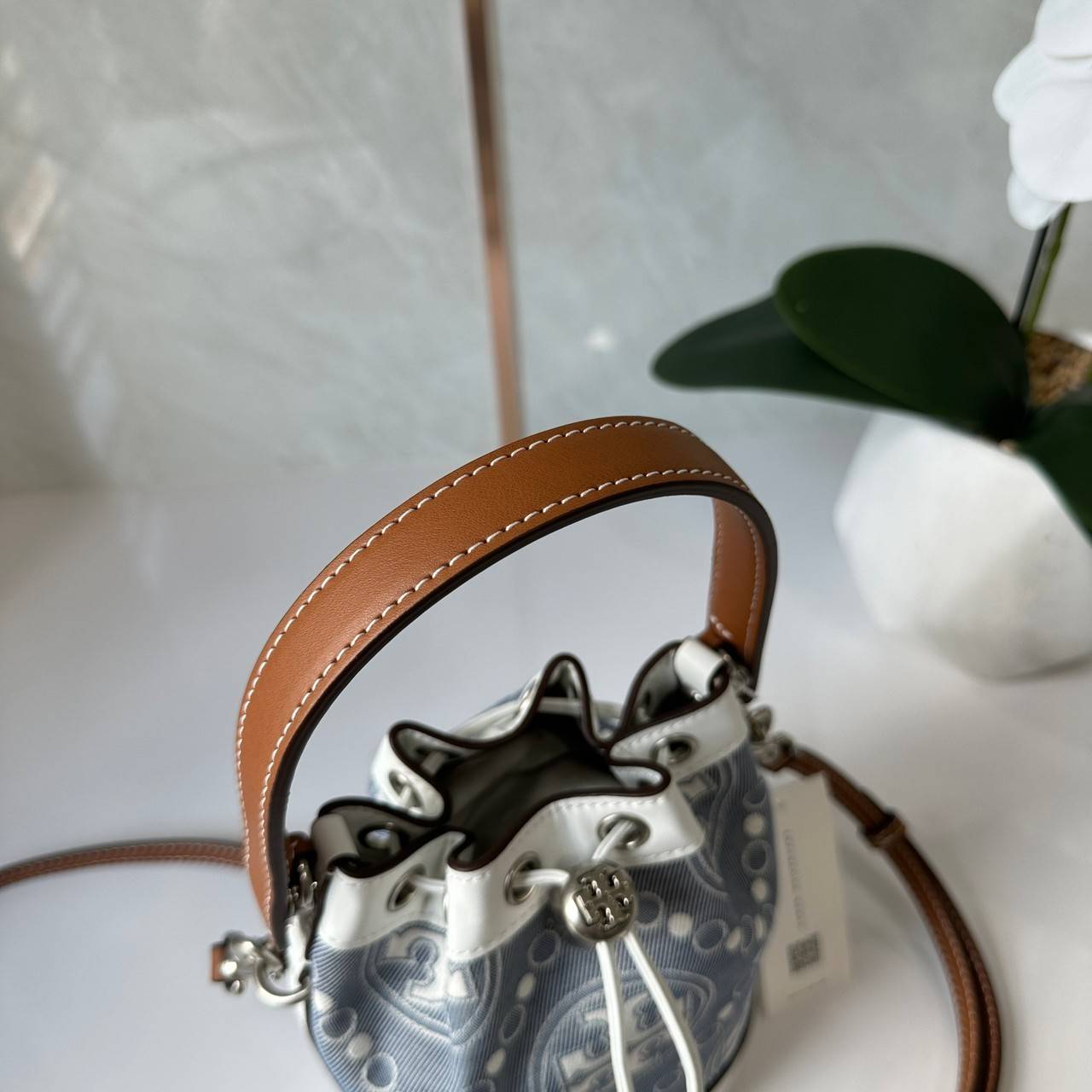 TORY BURCH Mini T Monogram Denim Bucket Bag คอลเลคชั่นใหม่ รูปแบบคลาสสิค พกพาความหรูหราไปได้ทุกที่ด้วยกระเป๋าทรง Bucket ขนาดกลางและปิดด้วยเชือกรูดพร้อมโลโก้แวววาว วัสดุผ้าเดนิมแจ็คการ์ด ตัดขอบหนังแท้ สวยหรู ทันสมัยสุดๆคะ