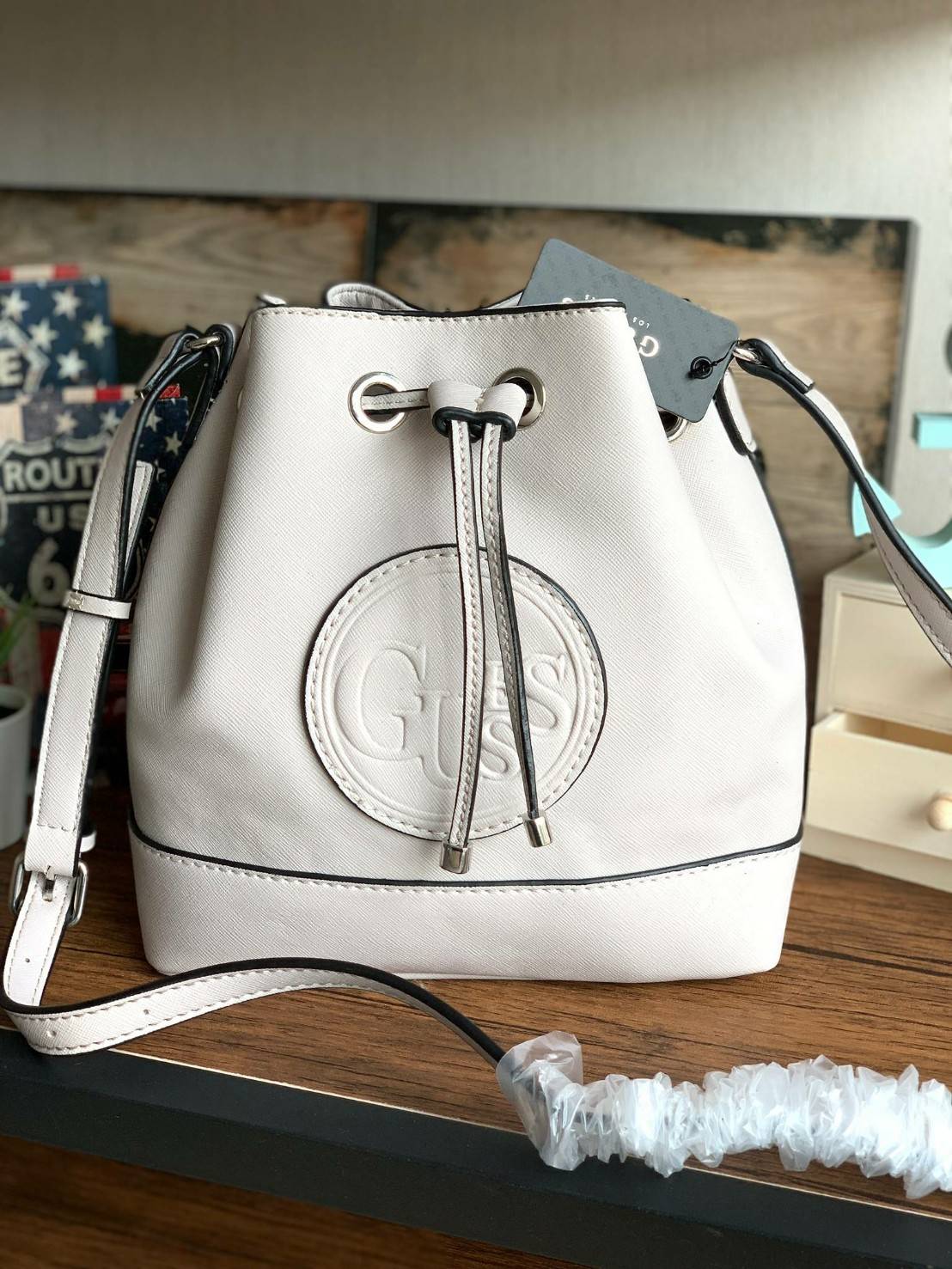 Guess Drawstring Bucket Bag กระเป๋าสะพายขนาดกลาง วัสดุลายหนังsaffiano ฐานกว้างตั้งอยู่ทรง มีซิกเนเจอร์ที่ด้านหน้าเป็นโลโก้ตัวนูน เปิดปิดแบบหูรูดและกระดุมแม่เหล็ก มีช่องใช้งานหลายข่อง สายสะพายปรับได้แบบเข็มขัด สวยแบบมีดีเทลเก๋ๆ สะพายเที่ยวระหว่างวันได้สบาย