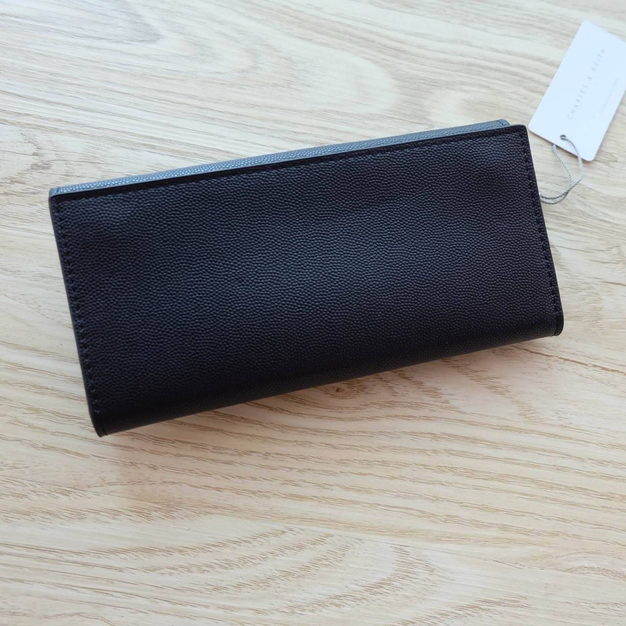 Charles & Keith Push-Lock Long Wallet กระเป๋าเงินใบยาววัสดุหนังลายคาร์เวียร์ ด้านหน้าปั๊มโลโก้แบรนด์ เปิดปิดแบบตัวล็อก ด้านในมีช่องซิปใส่เหรียญและธนบัตร ด้านหลัง มีตัวล็อคแบบกระดุม จุบัตรได้ถึง 12 ใบ รุ่นนี้สวยหรูเกินราคา ด้านหน้าเปิด - ปิดด้วยตัวกดล็อคทั