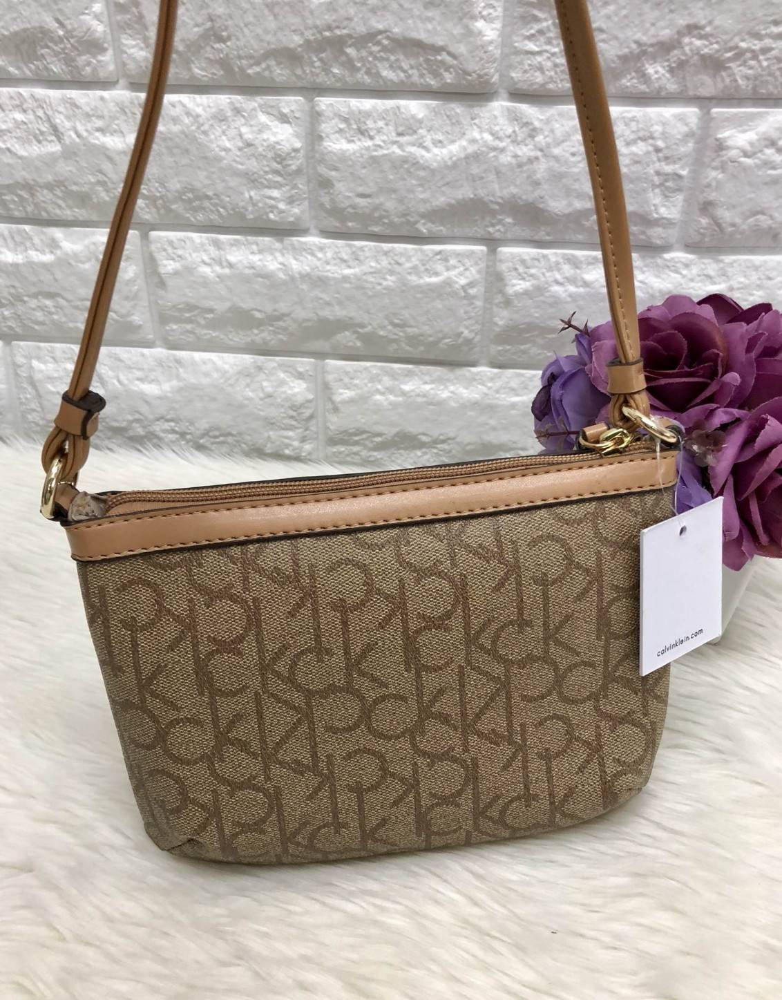 CALVIN KIEIN MINI CROSSBODY BAG กระเป๋าสะพาย size mini น่ารัก วัสดุหนังลายแบรนด์รอบใบ ด้านหน้าประกับ l0go brand อะไหล่ทอง เปิดปิดกระเป๋าแบบซิป ภายในโล่ง ใส่ธนบัตร, bookbank, มือถือได้ทุกรุ่น สายสะพาย เป็นหนังนิ่มสะพายสบาย ใบนี้ classic ตลอดกาลค่ะ