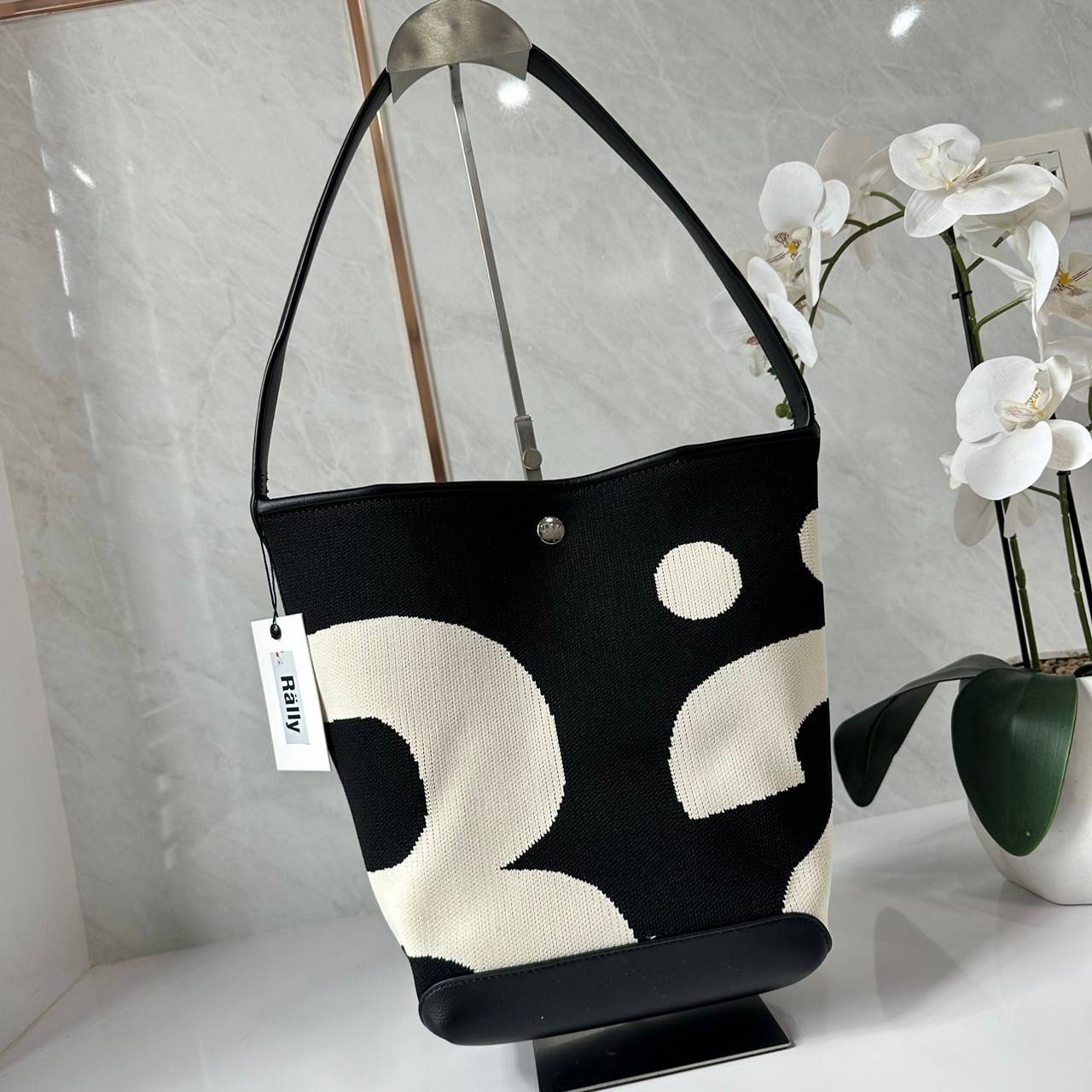 Rally movement the bag Knit Black เป็นไอเท็มที่ฮอตสุดๆแห่งปีจริงๆ กับกระเป๋าทรงบัคเก็ต น้ำหนักเบาๆ ฮอทติดลมบน จุของได้แบบหนำใจ ทอลายโลโก้ด้วยเทคนิค Sturdy Stretch Knit