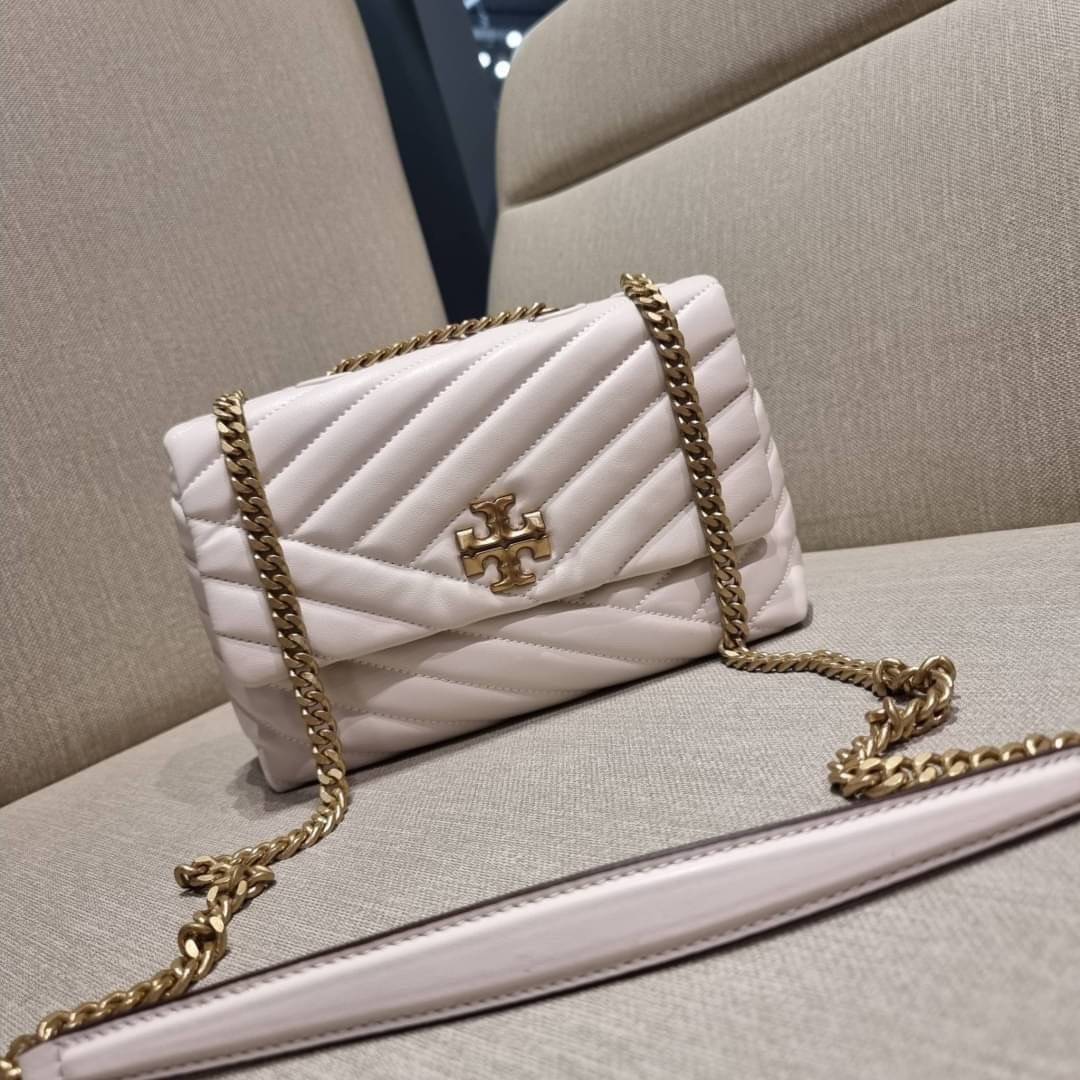 TORY BURCH KIRA CHEVRON CONVERTIBLE SHOULDER BAG (SMALL / MEDIUM) กระเป๋าสะพายรุ่นยอดฮิต ไซส์คลาสสิค ที่ใช้ยังไงก็ดูหรู ดีไซน์เฉพาะตัว วัสดุหนังแกะ สัมผัสนิ่ม เปิด-ปิดด้วยกระดุมแม่เหล็ก ภายในเป็นช่องโล่ง ใส่กระเป๋าสตางค์ มือถือ เครื่องสำอางค์ พาวเวอร์แบงค