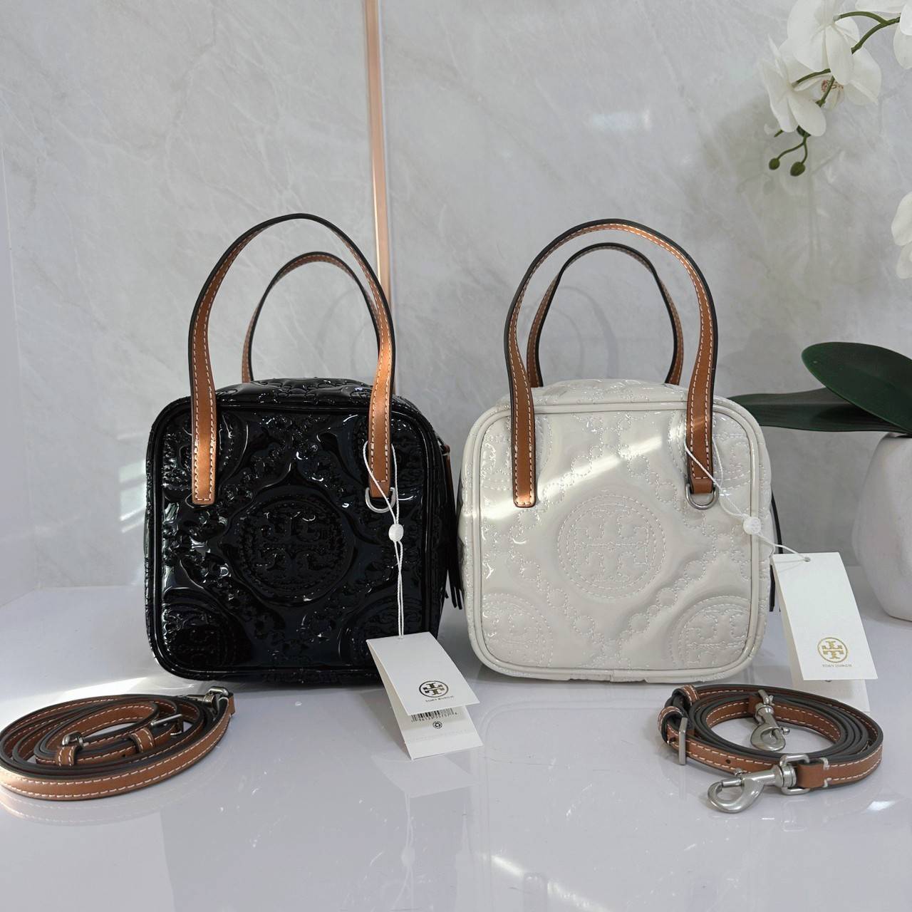 Tory Burch T Monogram Embroidered Patent Cube คอลเลคชั่นใหม่ รุ่นลิมิเต็ดรูปทรงใหม่ T Monogram สุดcube วัสดุหนังแท้ เปิด-ปิดด้วยซิป ภายในกว้าง มีช่องแยก 1 ช่อง สามารถใส่โทรศัพท์มือถือได้ทุกรุ่น สามารถถือหิ้วหรือสะพายได้ สายสามารถถอดและปรับระดับได้คะ