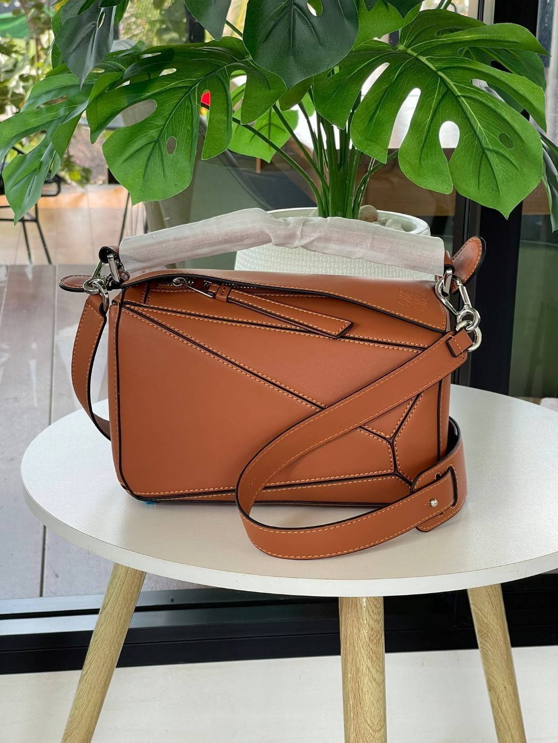 Loewe Puzzle Bag In Classic กระเป๋าทรง Puzzle นี้ออกแบบโดย Jonathan Anderson โดยได้รับแรงบันดาลใจในการออกแบบมาจากรูปทรงของลูกรักบี้ ดังนั้น จึงจะเห็นได้ว่าการตัดเย็บและรูปทรงของกระเป๋านั้นคล้ายคลึงกับลูกรักบี้ รูปทรงดูมินิมอลไม่ทิ้งคอนเซ็ปต์ของแบรนด์ สามา