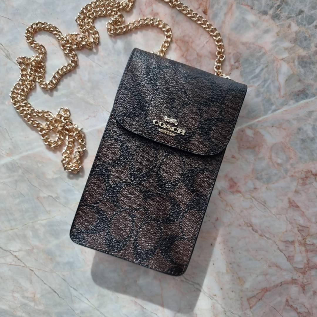 COACH NORTH/SOUTH PHONE CROSSBODY IN SIGNATURE CANVAS F55636 F39955 สุดคลาสสิคกับกระเป๋าสะพายเอนกประสงค์ Case phone ใส่โทรศัพท์มือถือได้ทุกรุ่น ดีไซน์ลายเอกลักษณ์ วัสดุหนังแคนวาสเคลือบลาย ฝาและภายในเป็นหนังสังเคราะห์เรียบ เปิด-ปิดด้วยกระดุม สายสะพายยาวประ