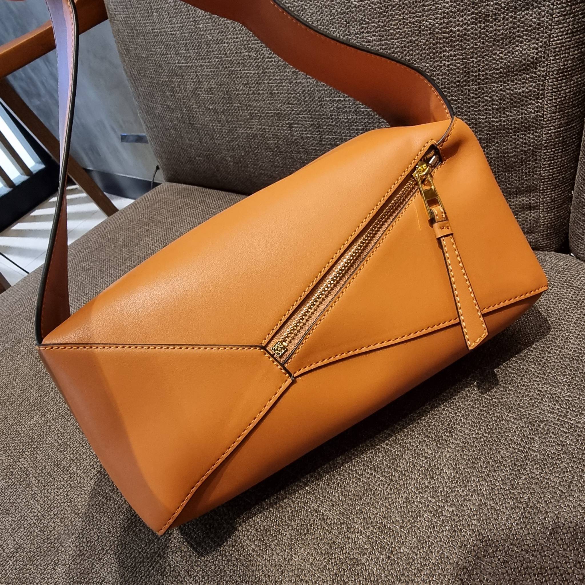 LOEWE PUZZLE HOBO BAG ใหม่ล่าสุด กับแบรนด์ที่มีดีไซน์โดดเด่นเป็นเอกลักษณ์ สวยหรูทุกรุ่นจริงๆ!! กระเป๋าสะพายโฮโบ ทรงสวย สไตล์พัซเซิลคลาสสิค วัสดุหนังวัวฟอกสี นิ่มมือ ฟินมาก!! เปิดใช้งานด้วยซิป ที่ภายในโล่งกว้าง ใส่ของสำคัญได้ครบไม่มีพลาด แบบสบายๆ มาพร้อมสา