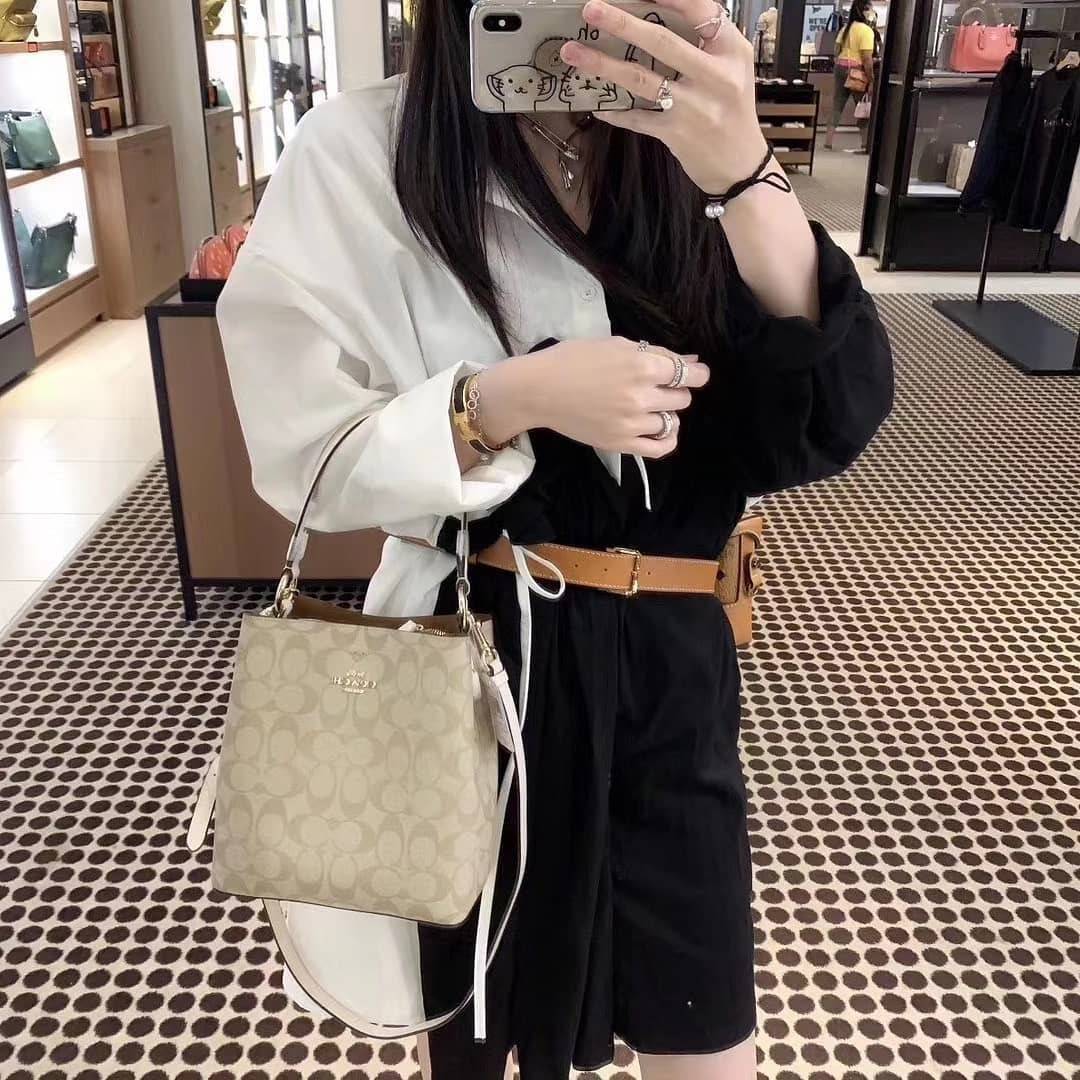 COACH 2312 SMALL TOWN BUCKET BAG IN SIGNATURE CANVAS รุ่นยอดนิยมใบเล็กมาครบสีแล้วจ้า กระเป๋าทรงบัคเก็ต สีผู้ดี๊ผู้ดี ตัวกระเป๋าดีไซน์คลาสสิคลายซี ดูโดดเด่น วัสดุหนังแคนวาสเคลือบลาย สวยคมทุกมุมจริงๆ!! เปิด-ปิดด้วยกระดุมแม่เหล็กทั้ง 2 ฝั่ง ภายในเป็นช่องโล่ง
